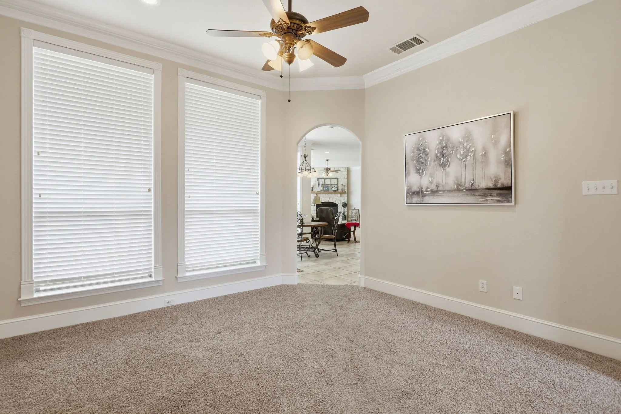 Neutral tone wall paint with white trim, a decorative arched doorway, and recessed lighting
