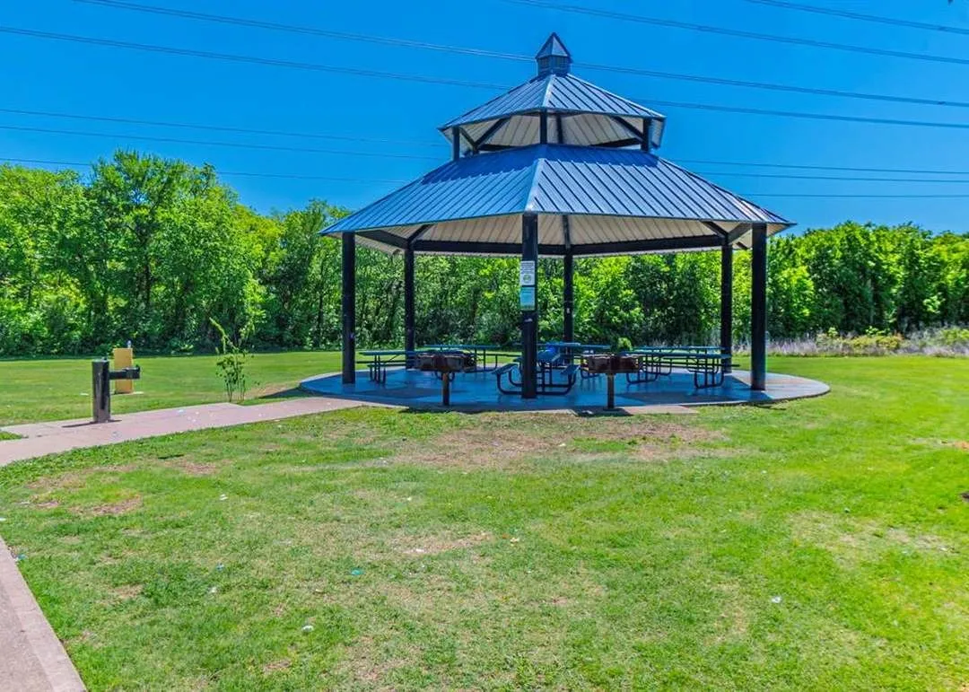 Open-air gazebo featuring a multi-tiered metal roof and a concrete base