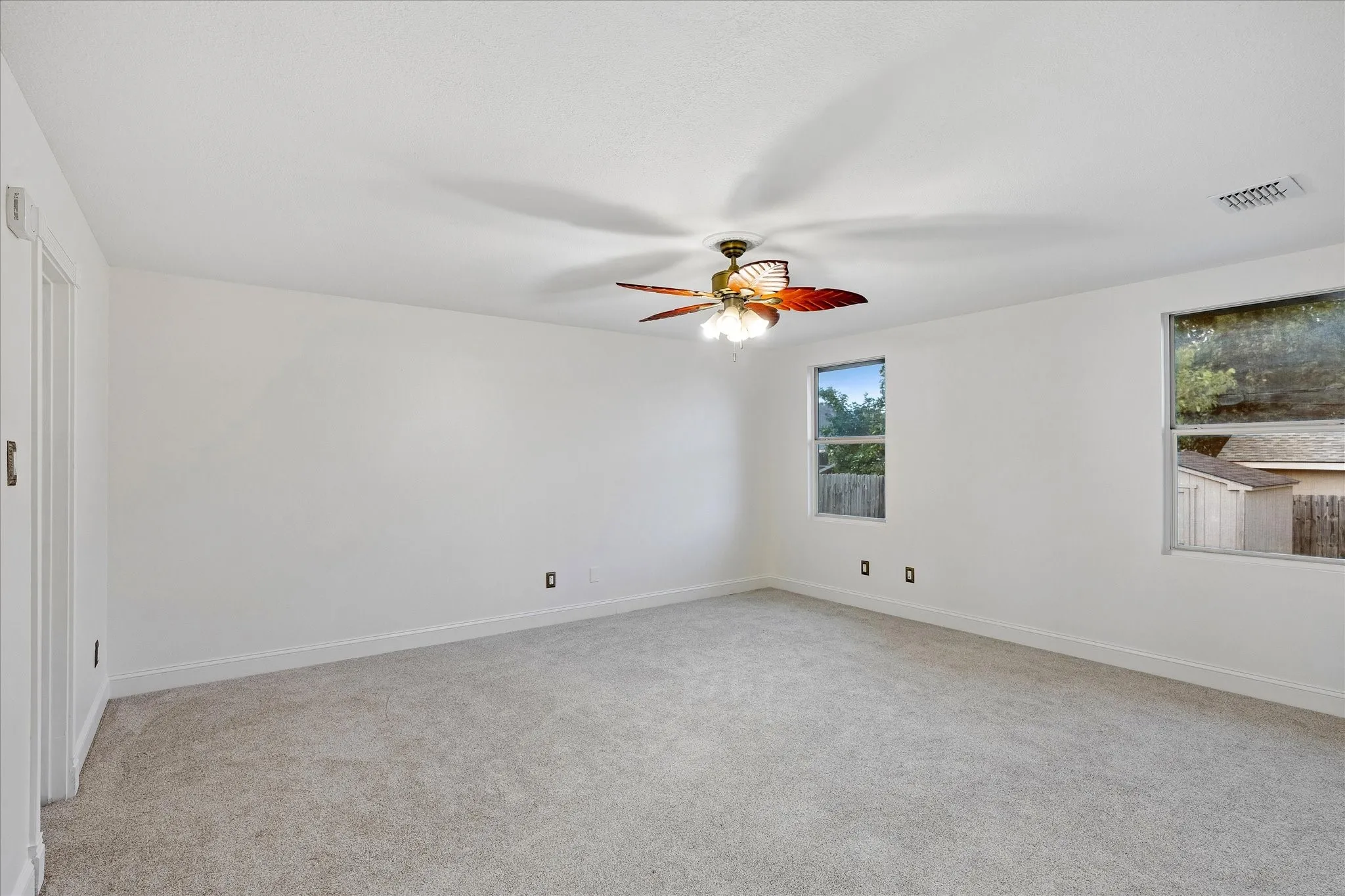 Spacious room featuring light-toned carpeting and white walls
