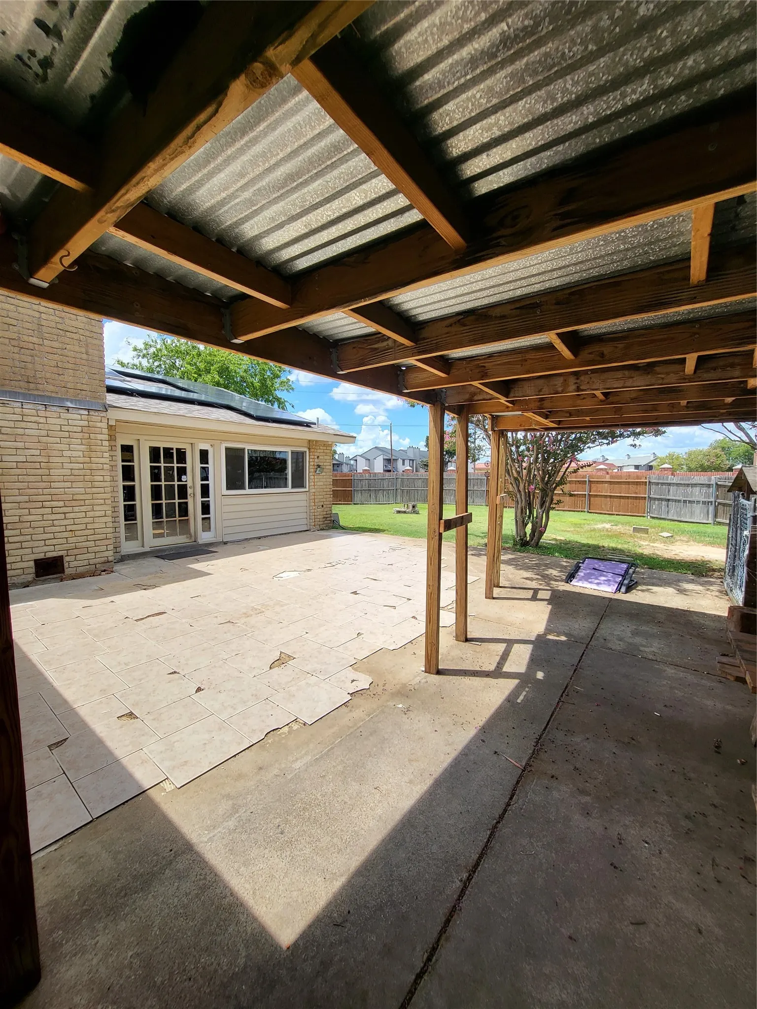 Covered patio area with a corrugated metal roof and exposed wood beams