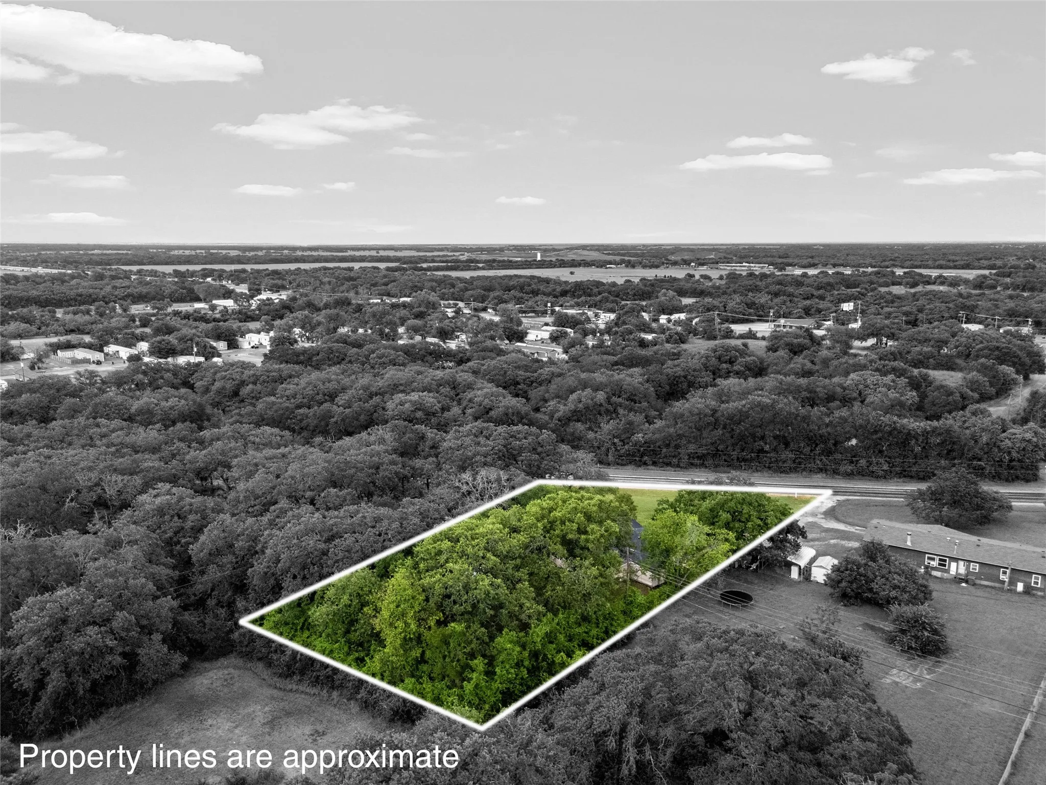 Aerial view highlighting a rectangular lot with mature trees