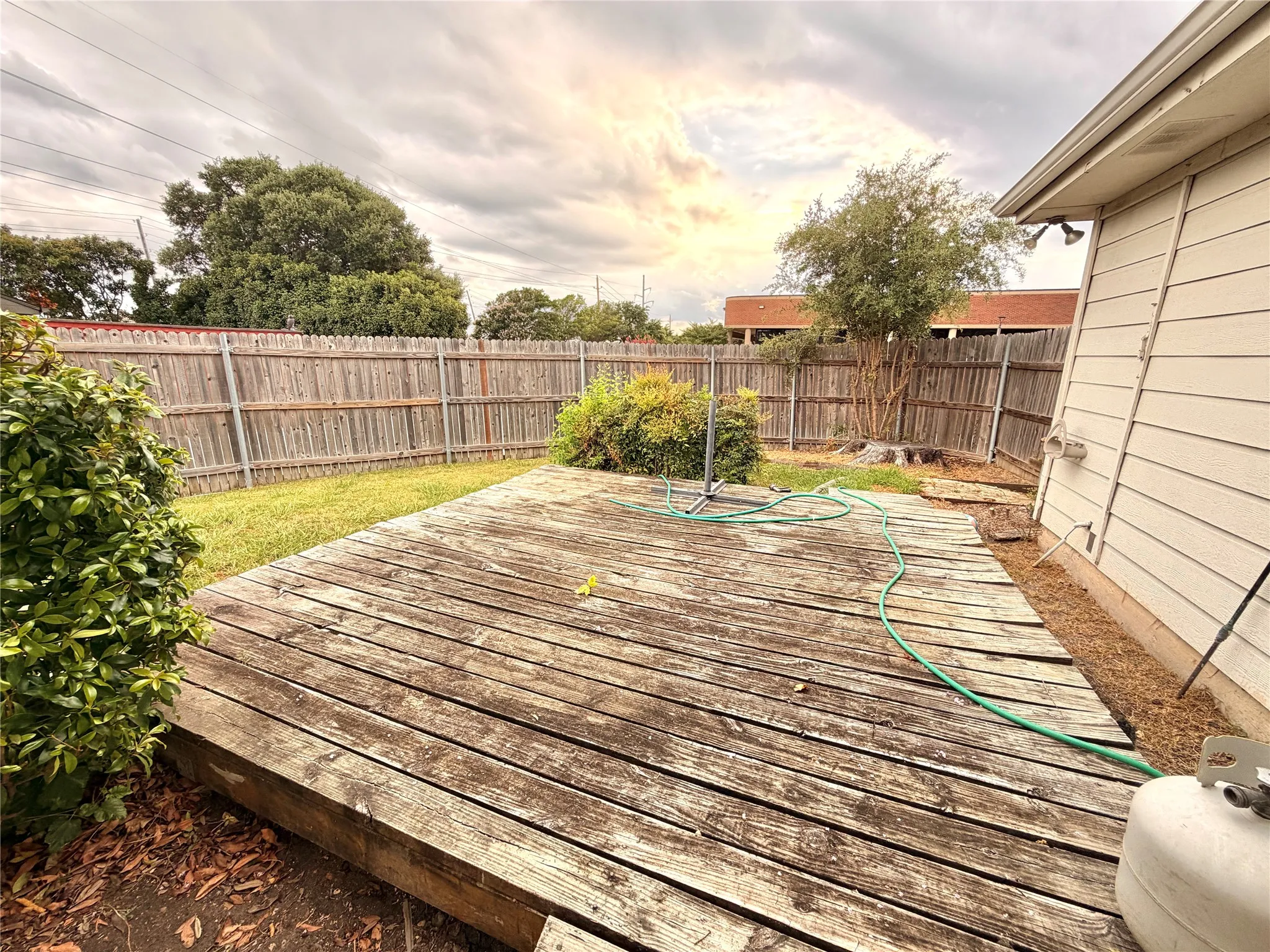 Expansive wood deck with plank construction, surrounded by a wood privacy fence