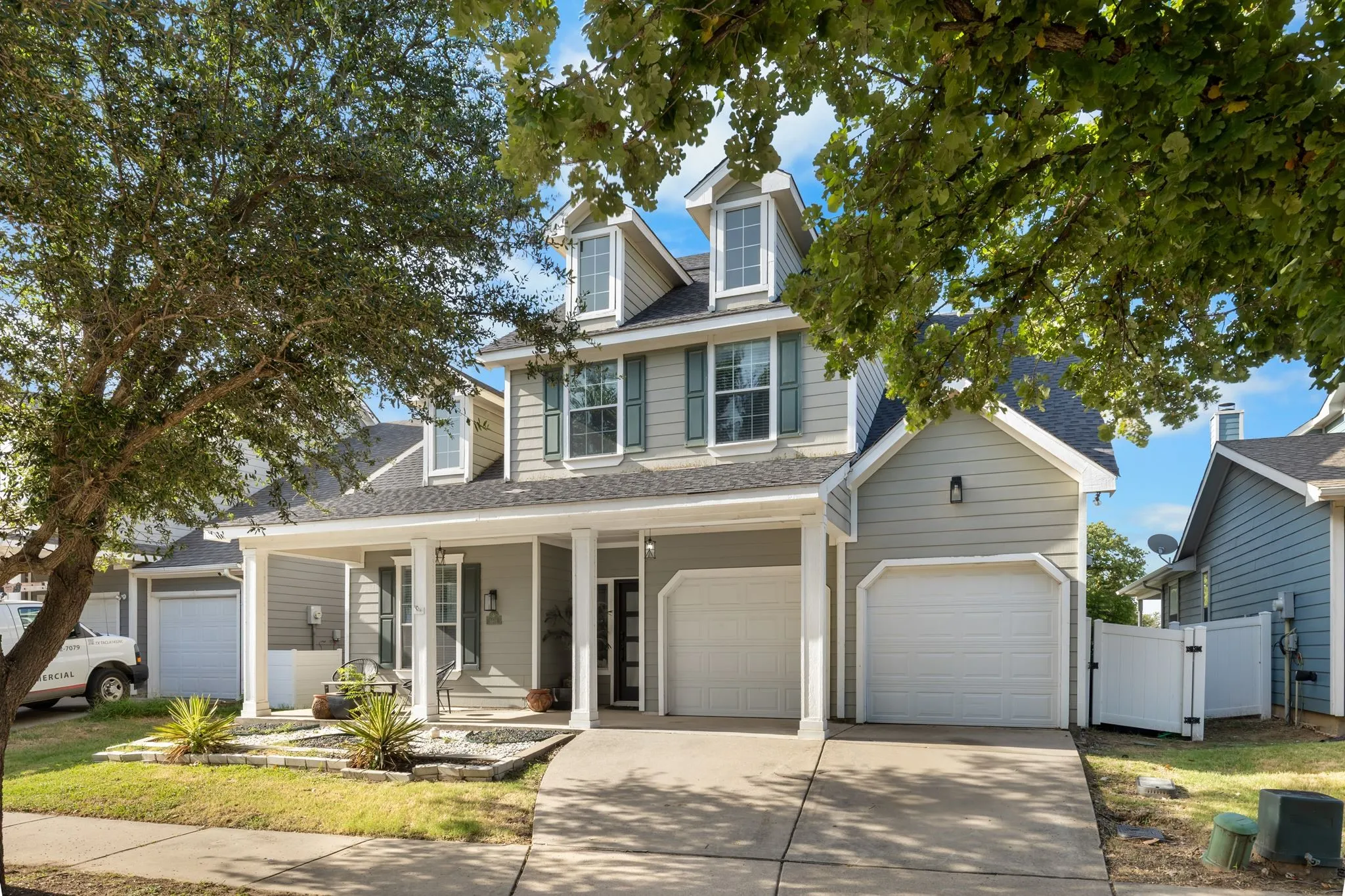 Two-story residence featuring light gray siding with dark green shutters