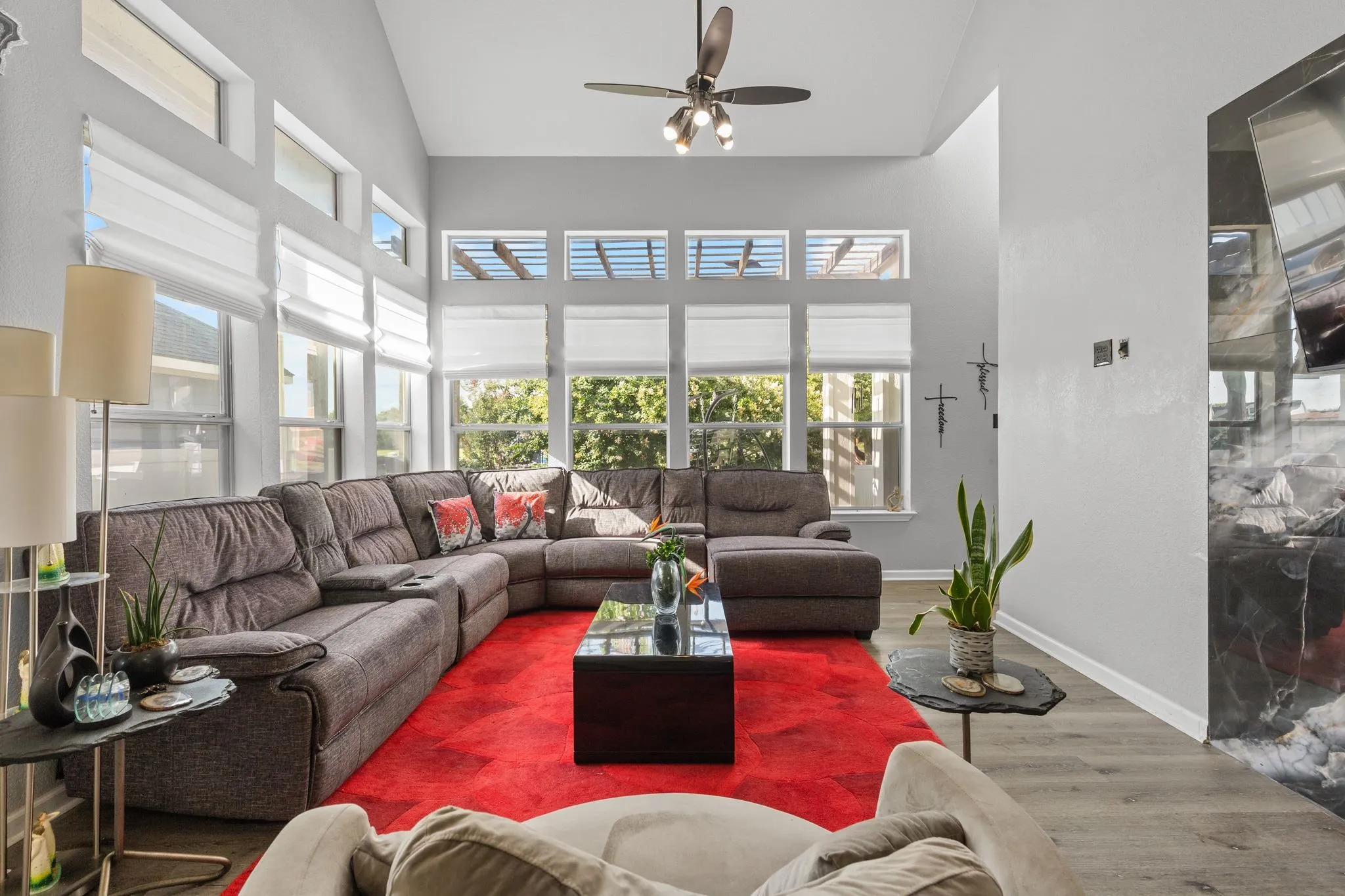 Vaulted ceilings highlight this living space, featuring abundant natural light from multiple windows