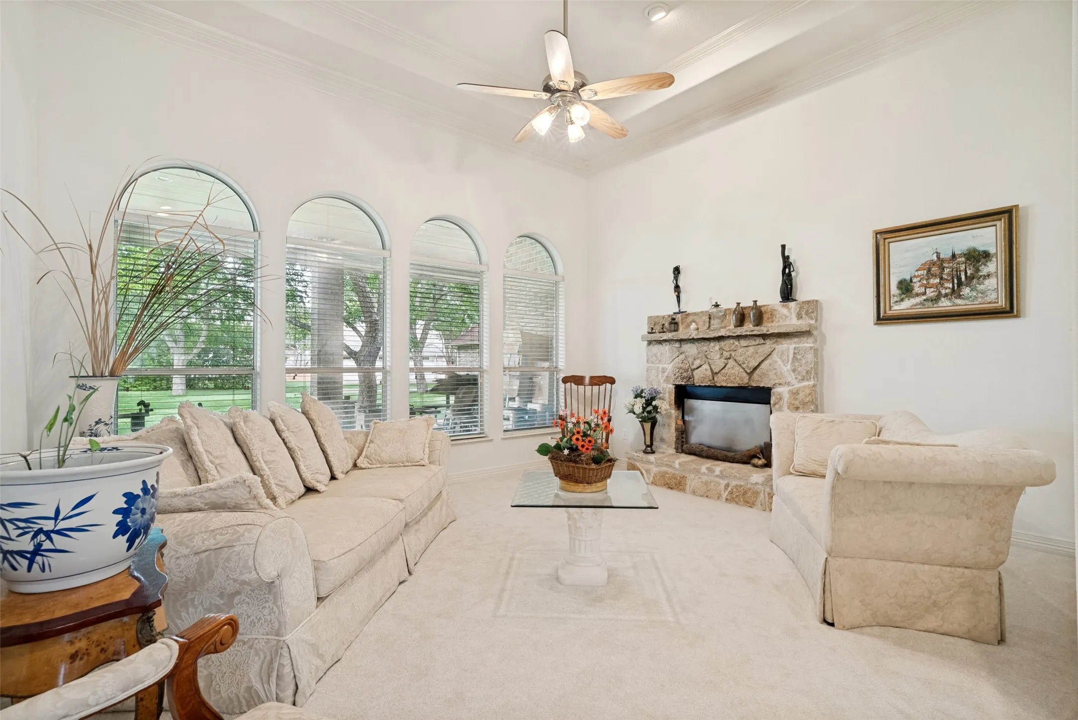 formal living featuring high ceilings, large windows, and wood burning fireplace