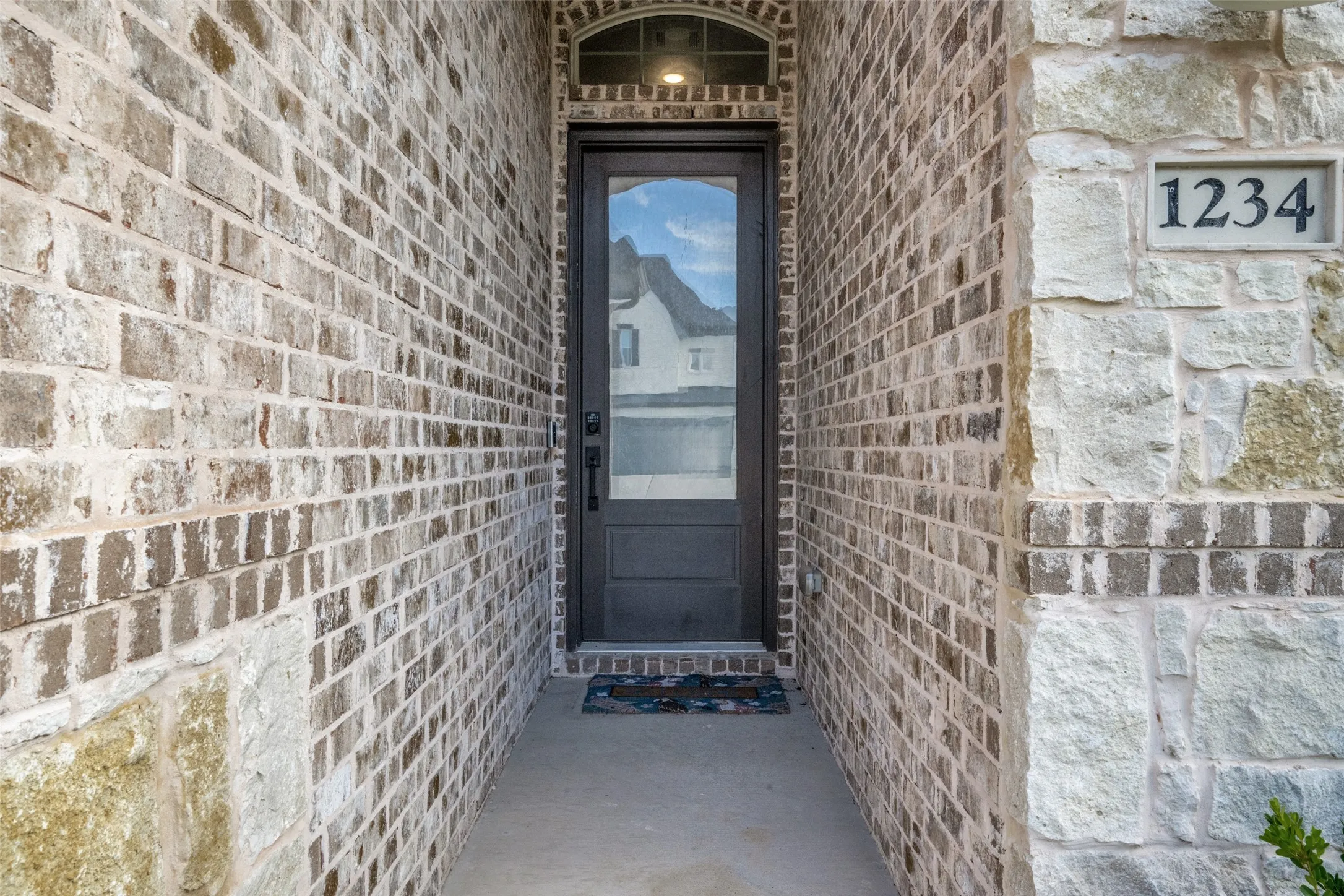 Inviting entry featuring a dark-paneled door with glass insert and an arched transom window