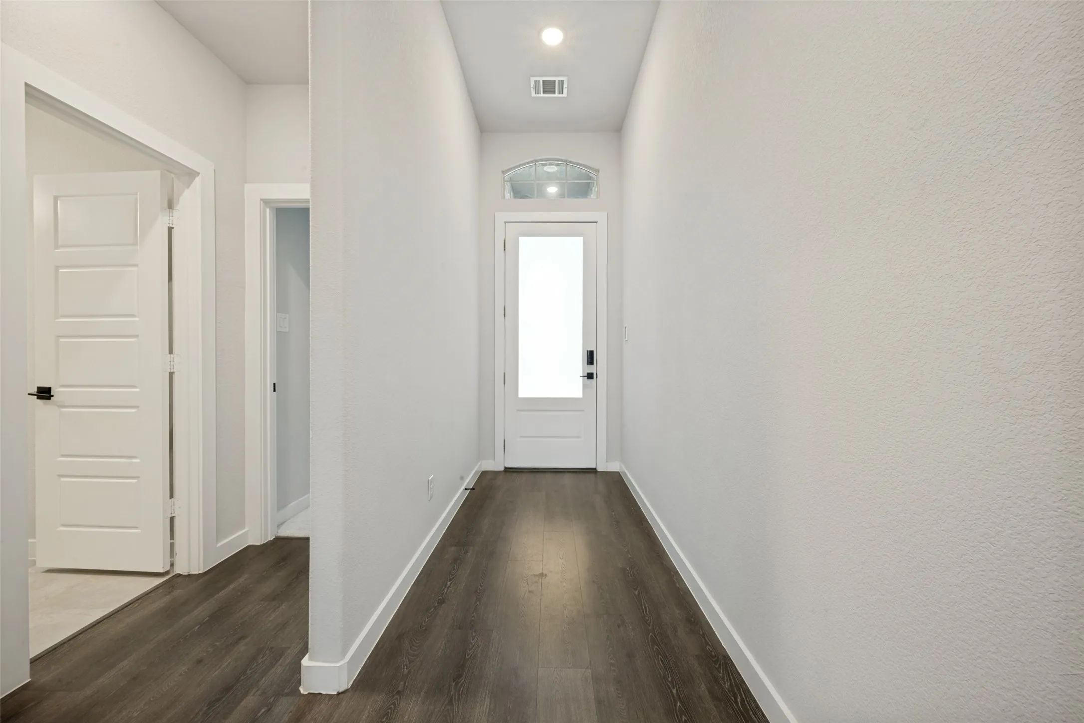 Entryway corridor featuring wood-finish flooring, white walls, and a recessed ceiling light