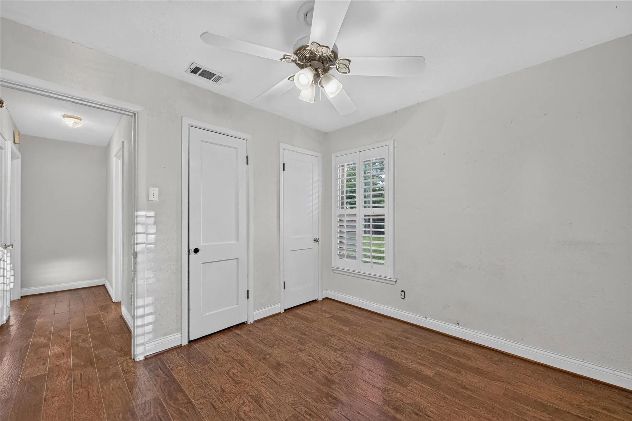 Room featuring wood-finish flooring, light gray wall paint, and white trim