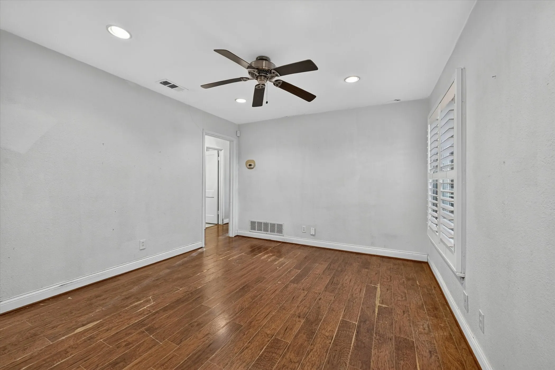 Spacious room featuring wood-finish flooring and a neutral color palette