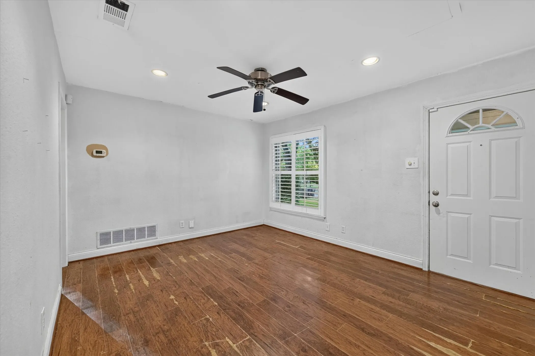 Room featuring wood-finish flooring, recessed lighting, and a ceiling fan