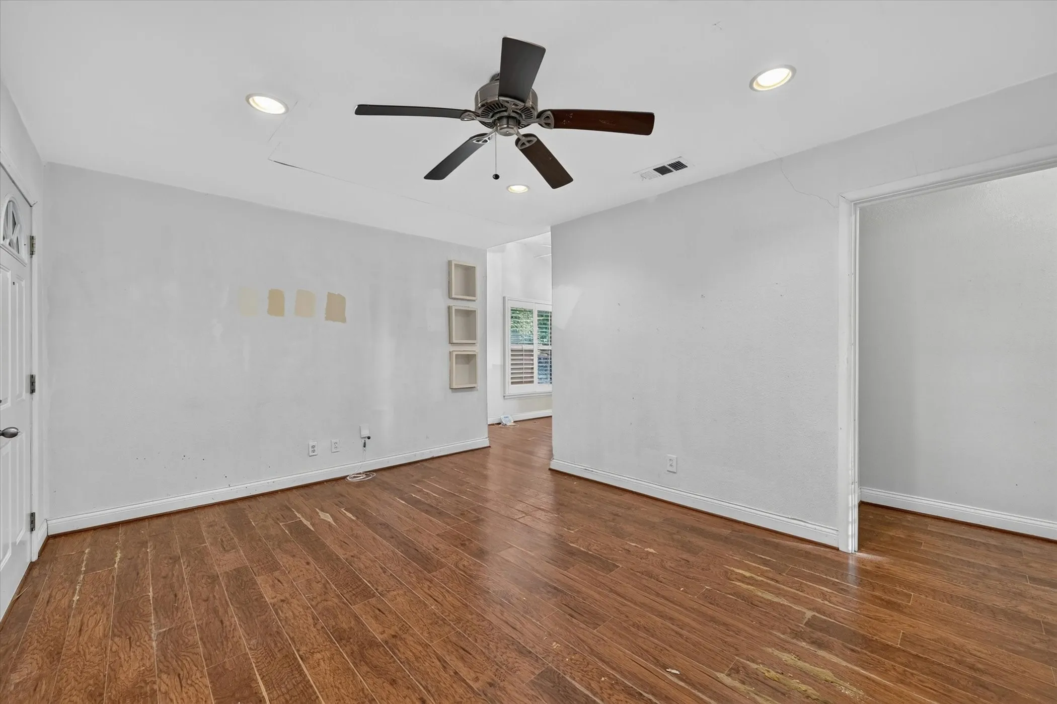 Spacious room featuring wood-finish flooring, recessed lighting, and a ceiling fan