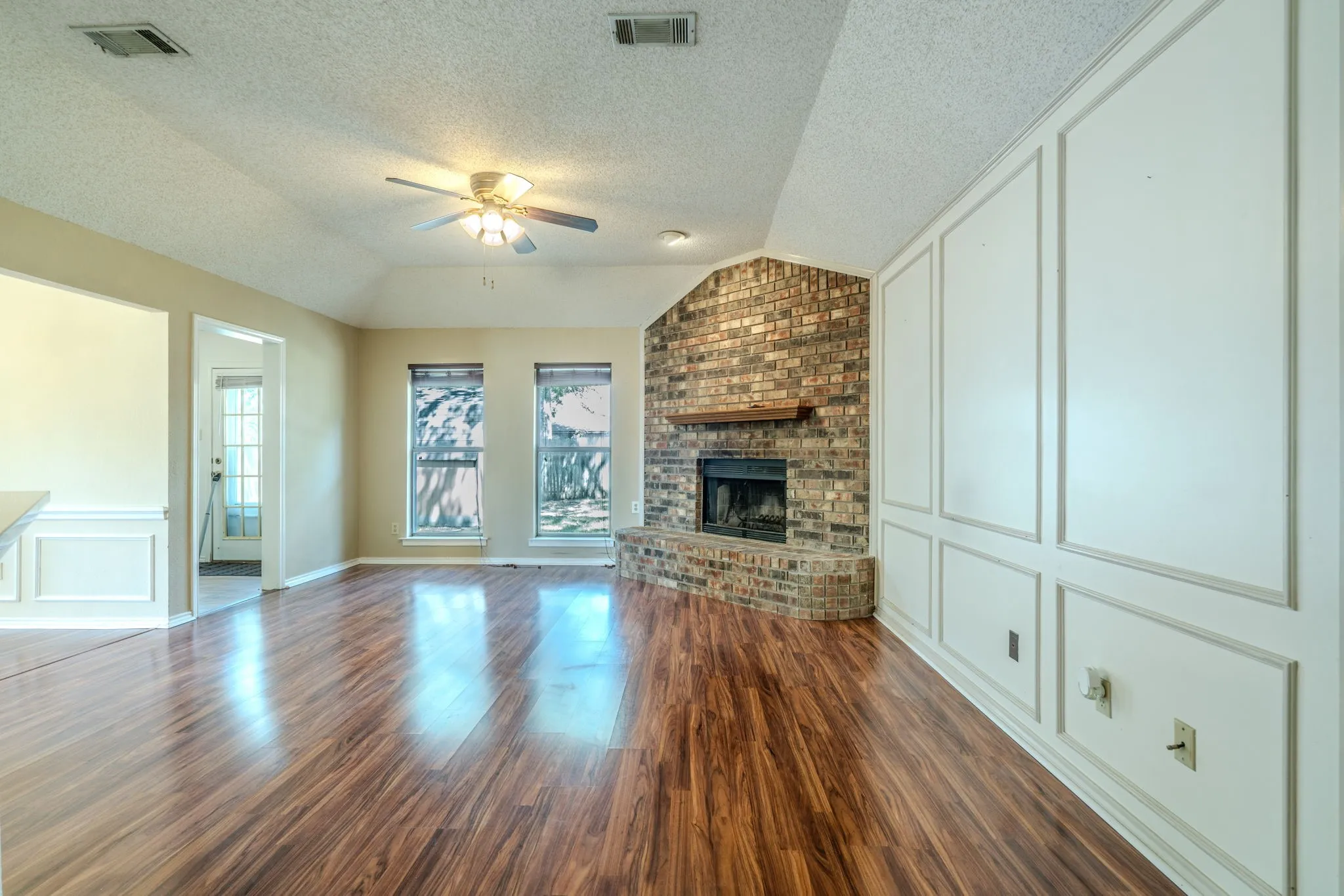Another view of the living area featuring picture pane paneling and beautiful vinyl plank flooring.