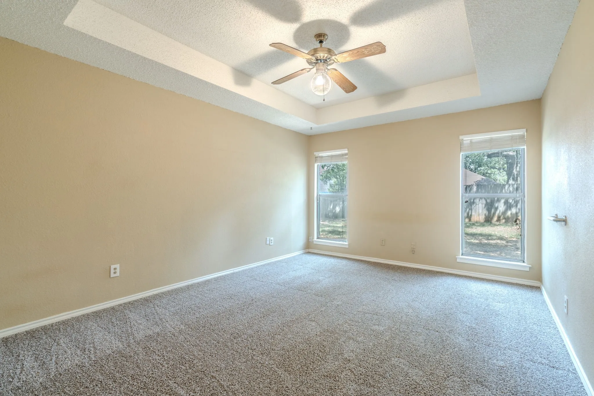 Primary bedroom with cathedral ceiling and lots of natural light.