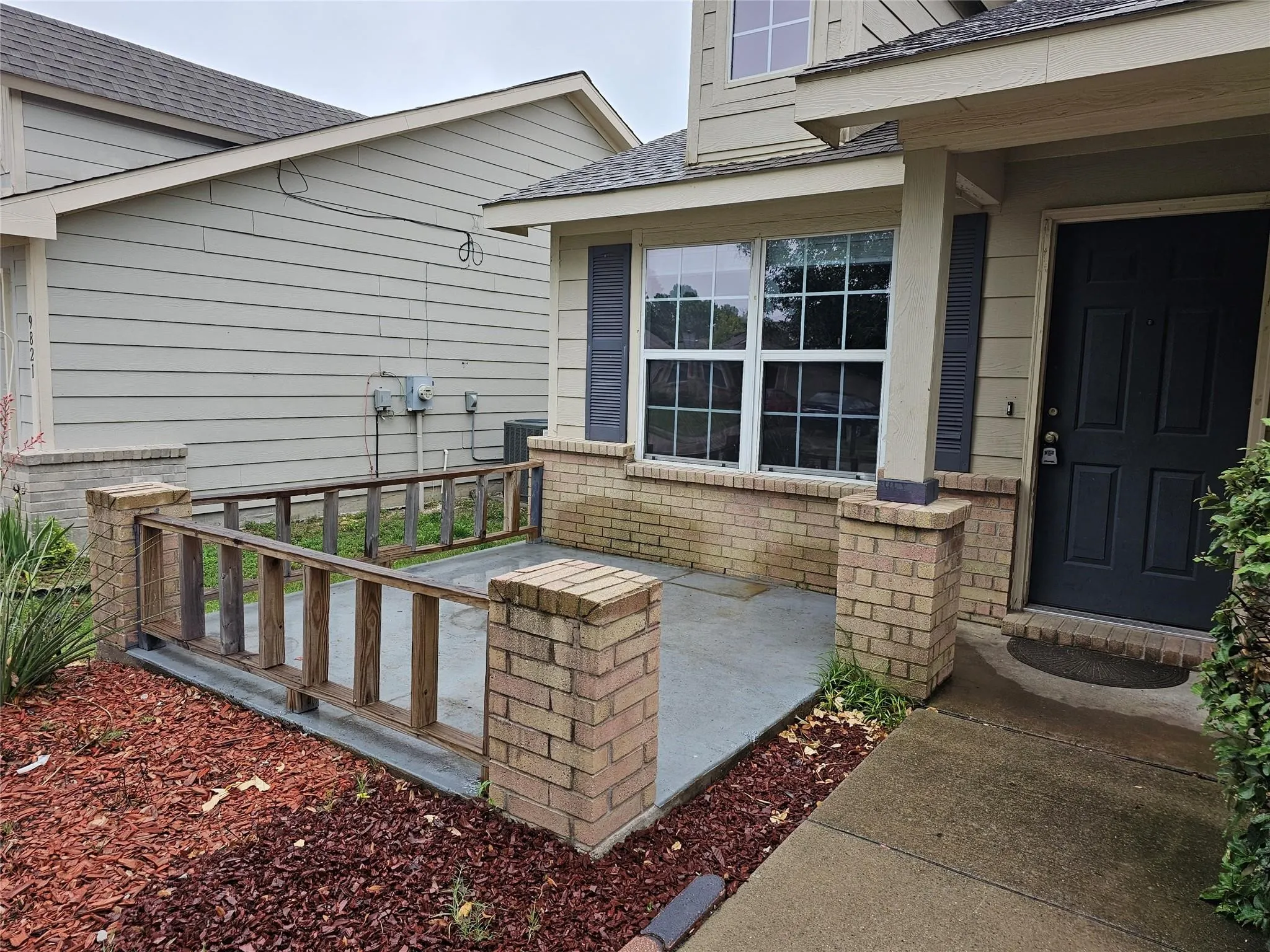 Doorway to property with roof with shingles and brick siding