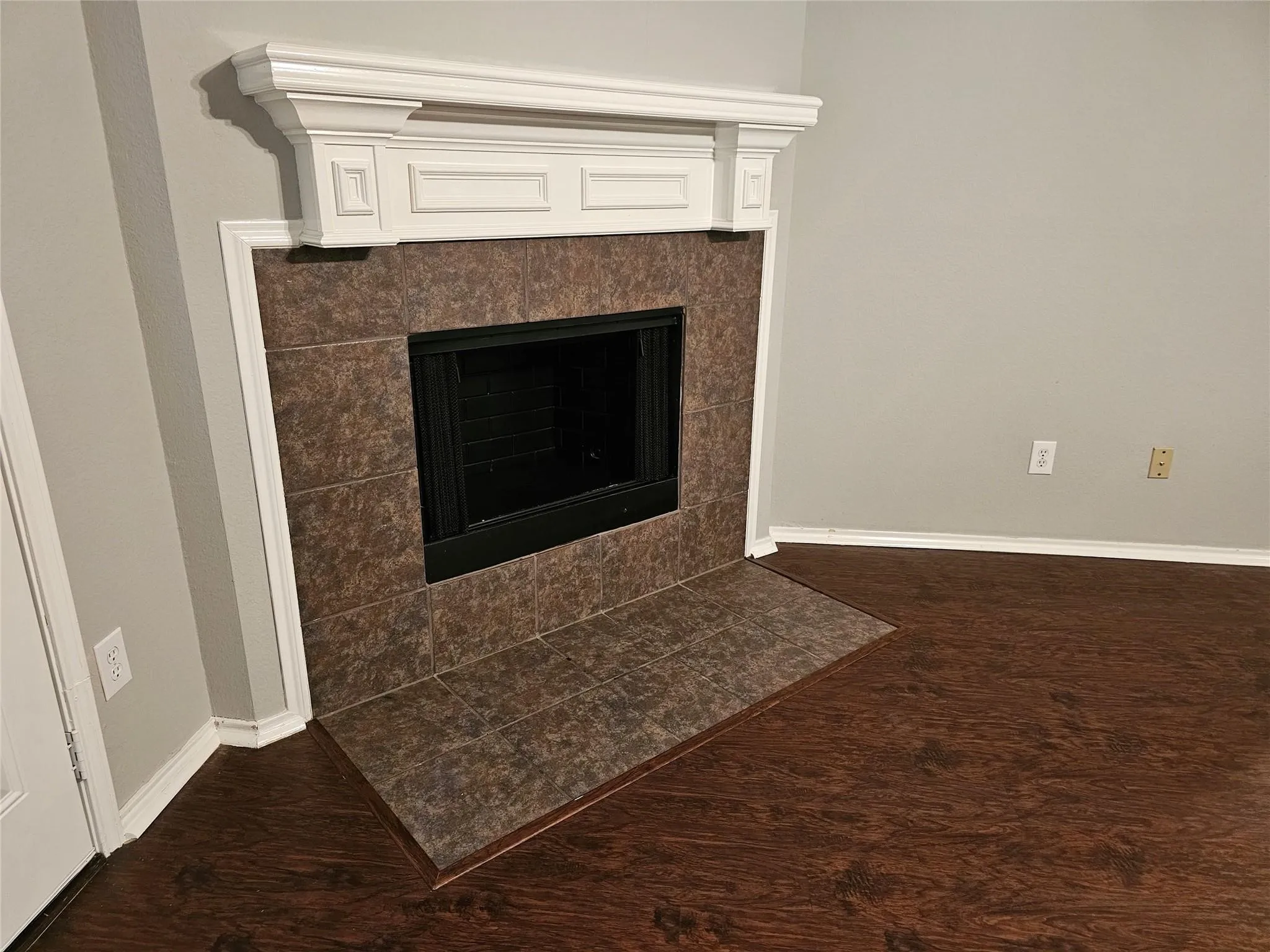 Detailed view of a fireplace and wood finished floors