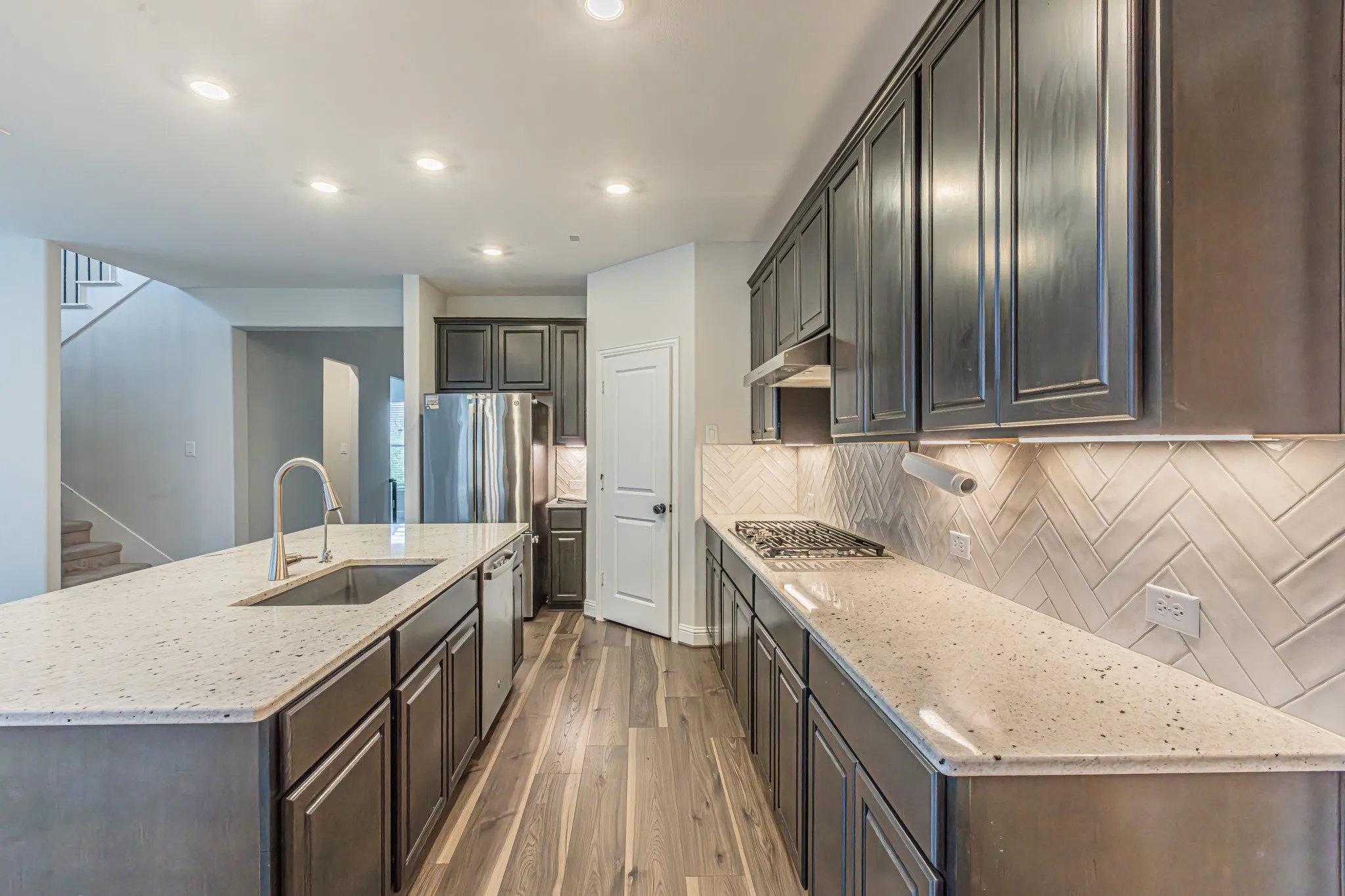 Contemporary kitchen featuring an expansive island with an undermount sink and gooseneck faucet