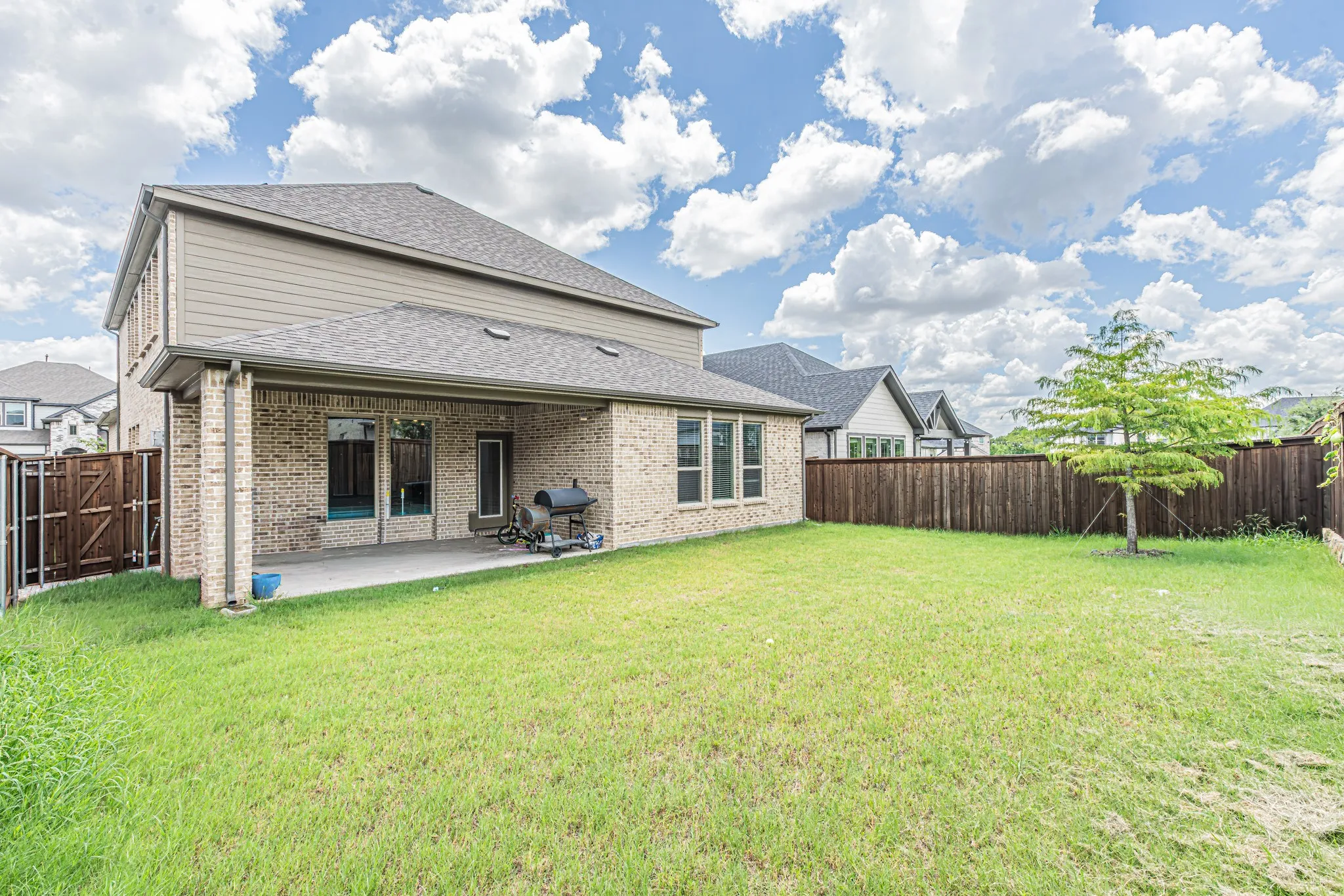 Expansive backyard featuring a lush lawn and a wood privacy fence