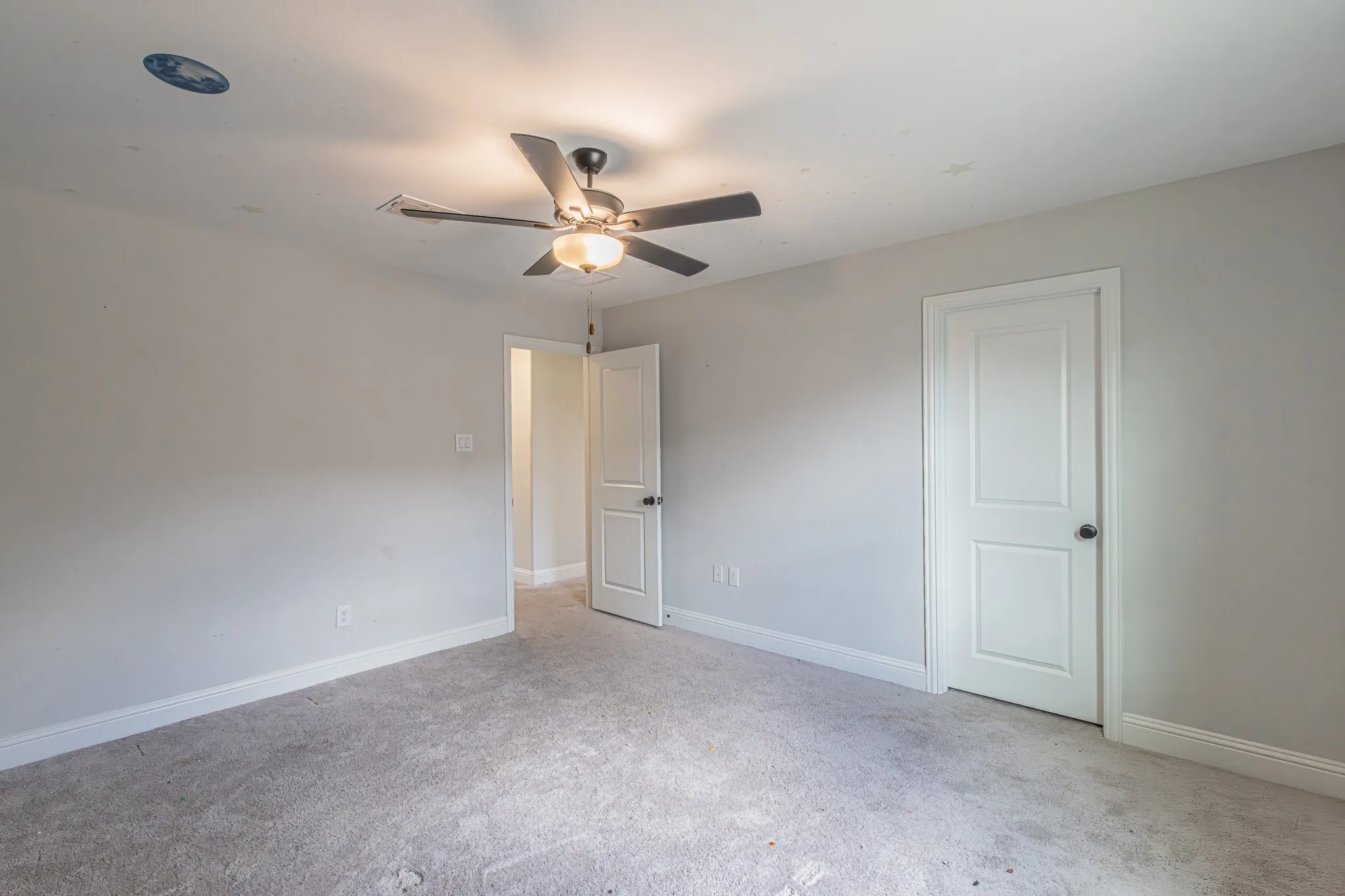 Carpeted room featuring a ceiling fan with integrated lighting, recessed lighting, white baseboards, and a paneled interior door