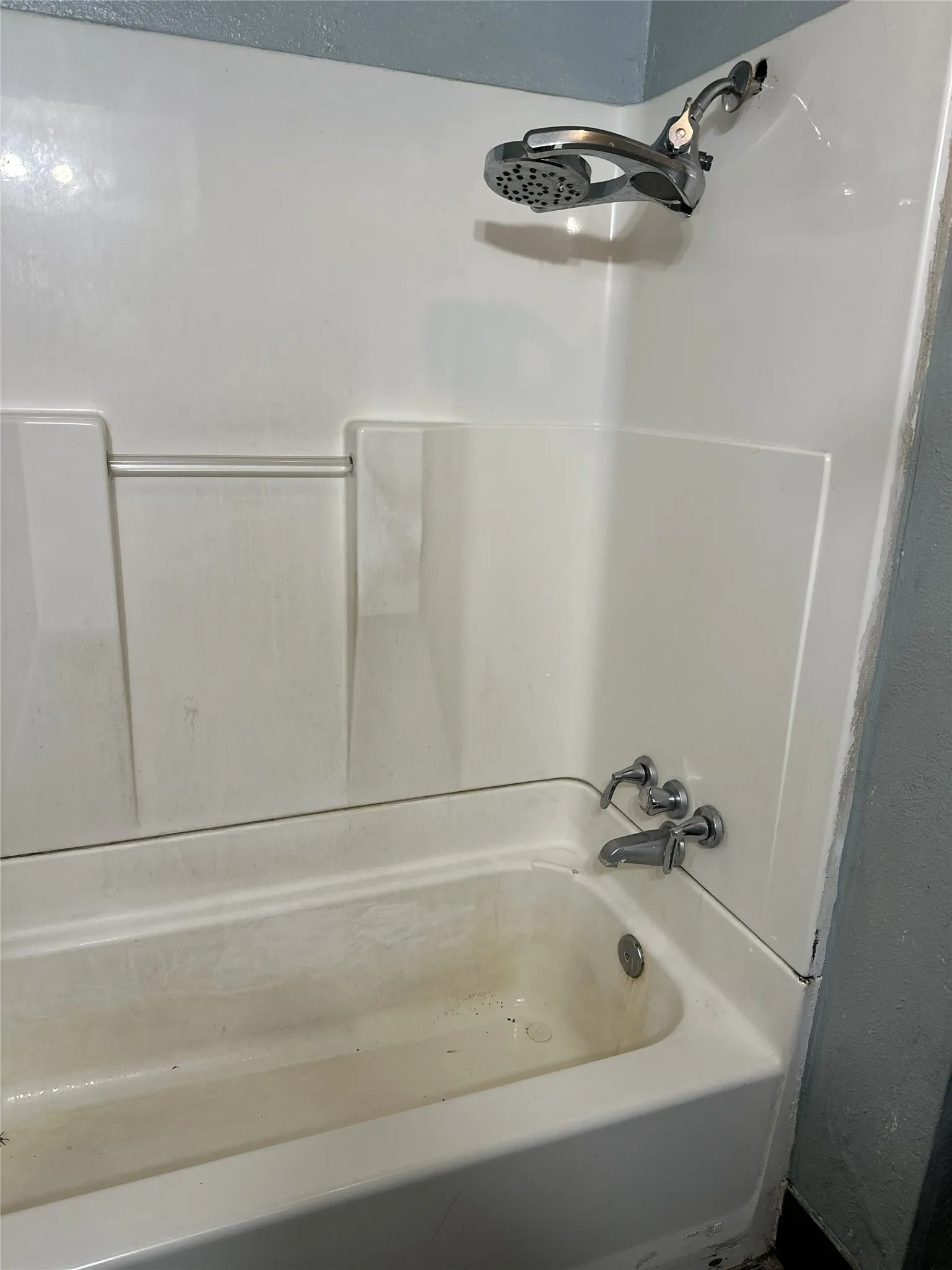 White tub and shower combination with chrome fixtures