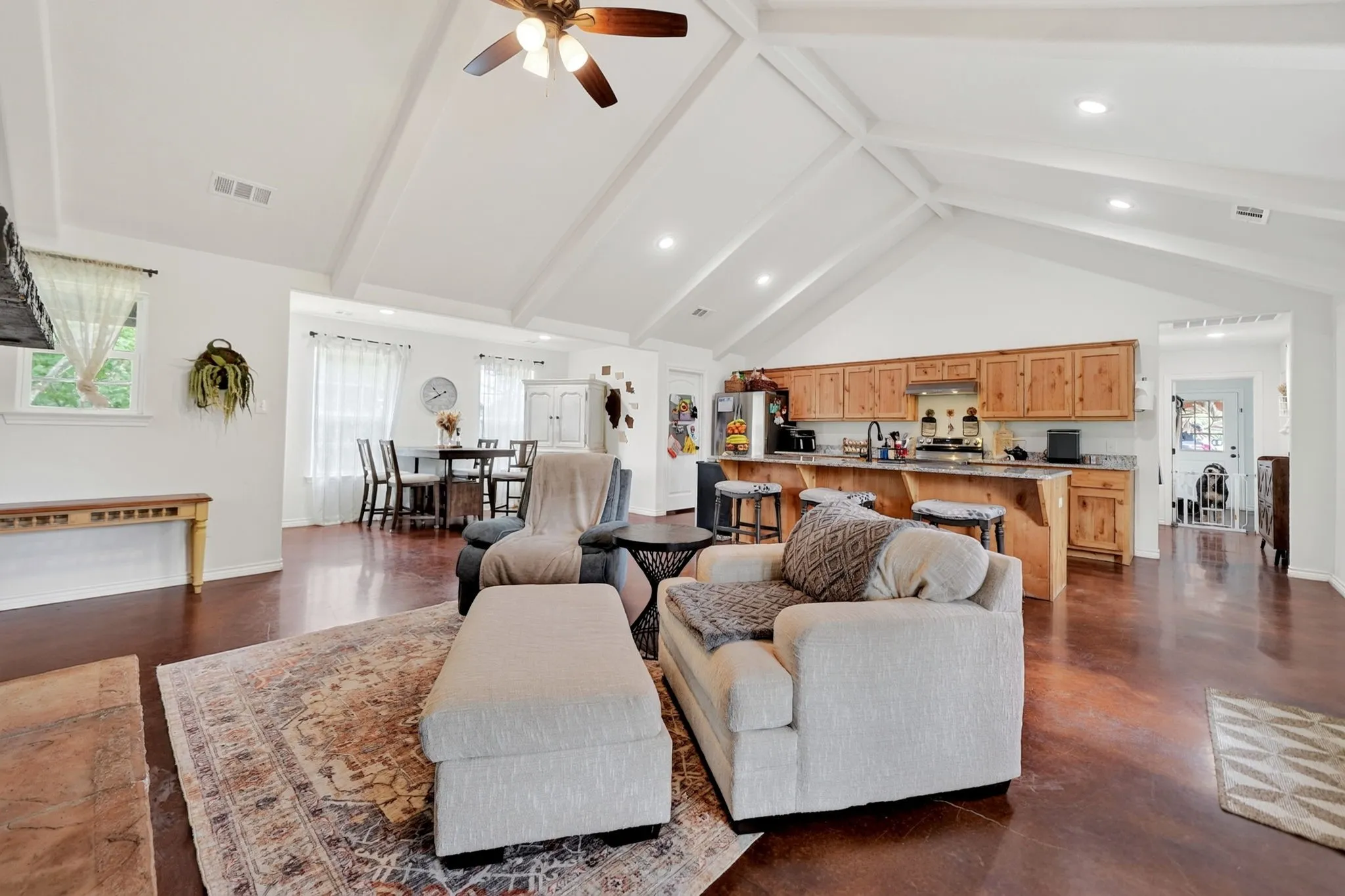 Vaulted ceiling with exposed beams, recessed lighting, and a ceiling fan