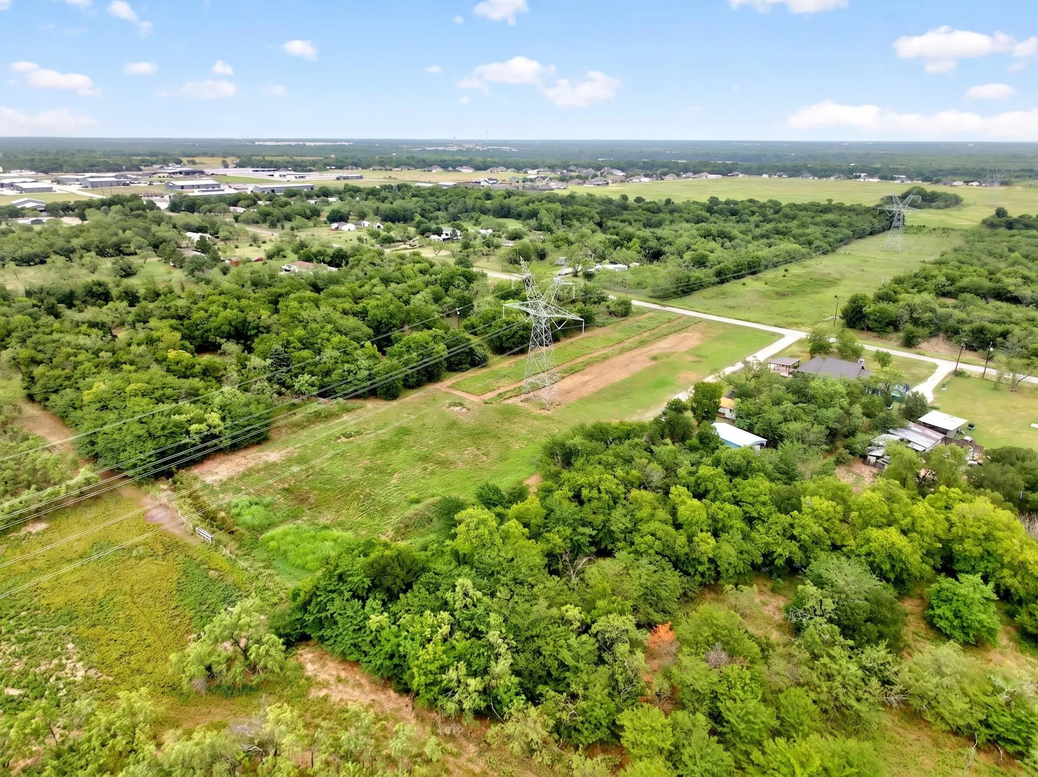 Expansive rural landscape featuring a mix of cleared land and mature trees