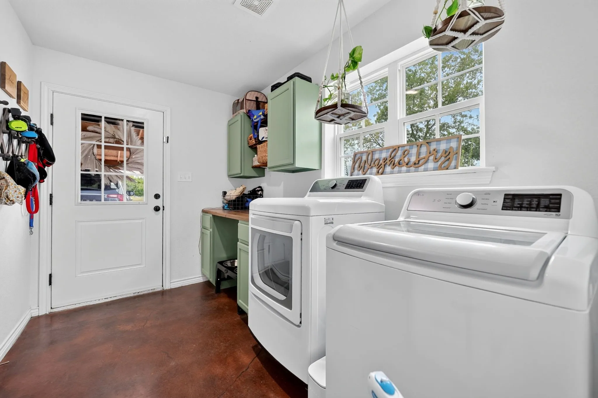 Laundry area featuring high-efficiency appliances, a window with multiple panes, and built-in cabinetry