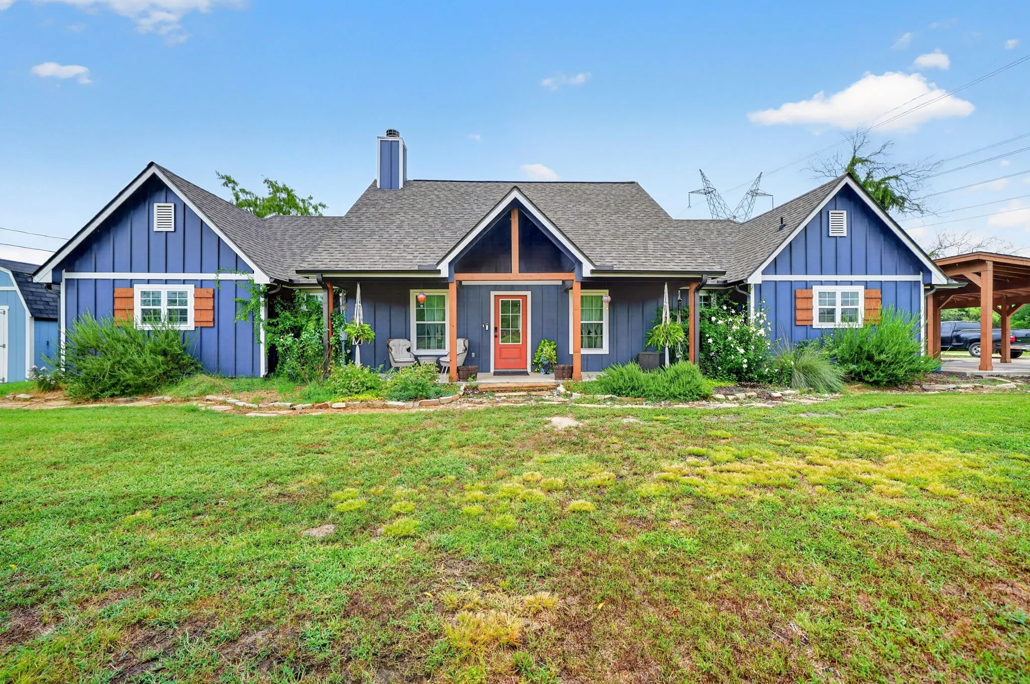 Blue exterior with white trim, a striking red front door, and a covered front porch entry