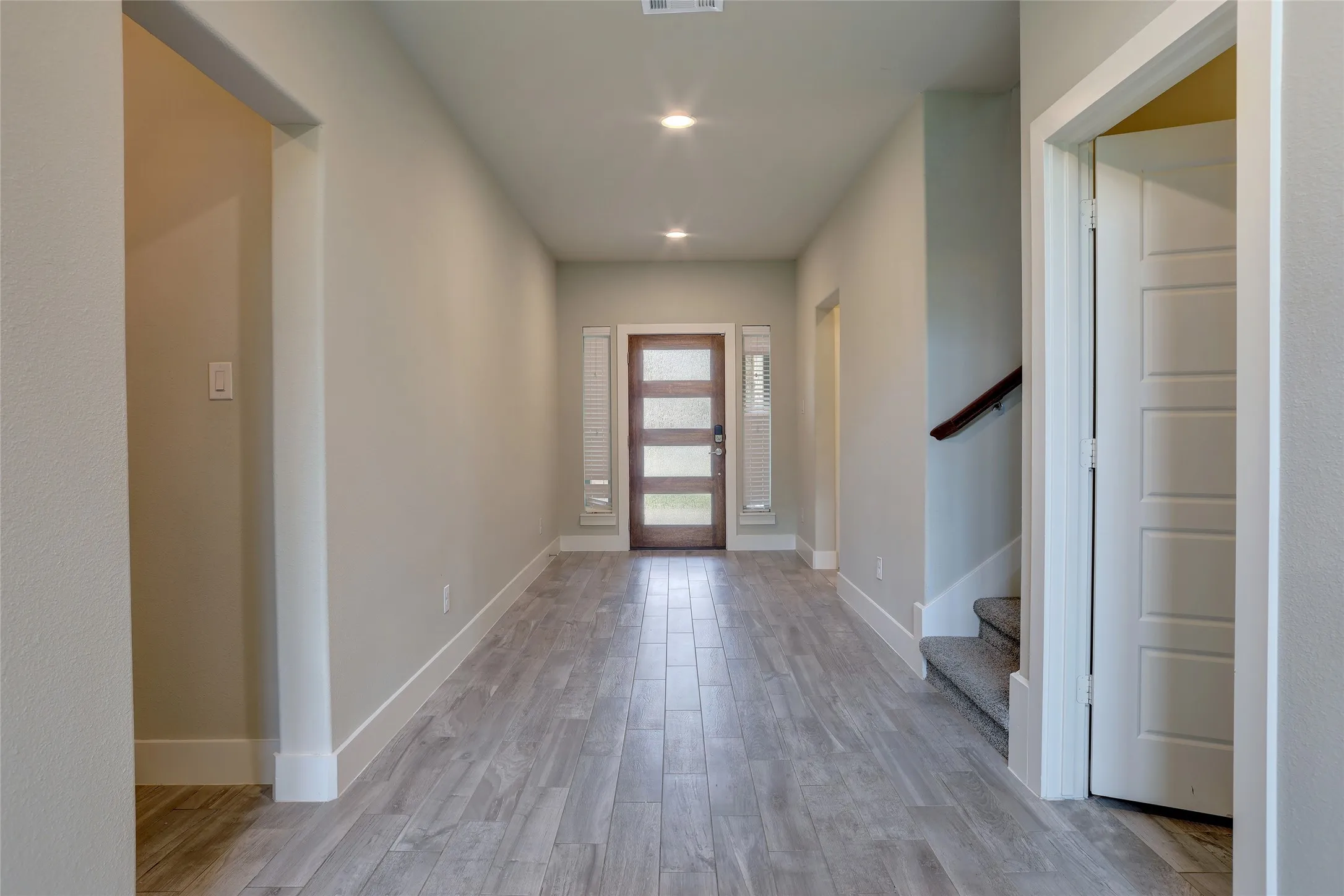 Entryway featuring wood-look flooring, light gray wall paint, recessed lighting, and a contemporary frosted glass paneled front door