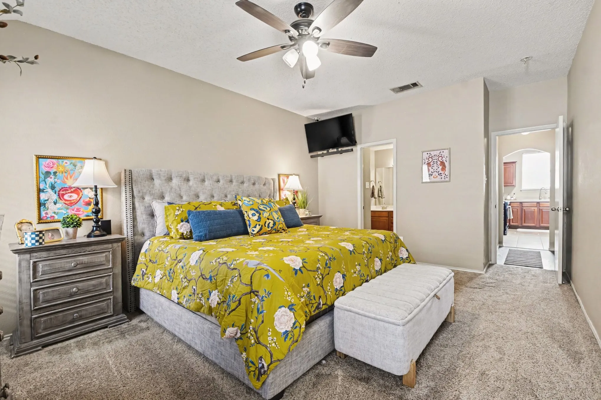 Spacious bedroom featuring carpet flooring, vaulted ceilings, and a ceiling fan