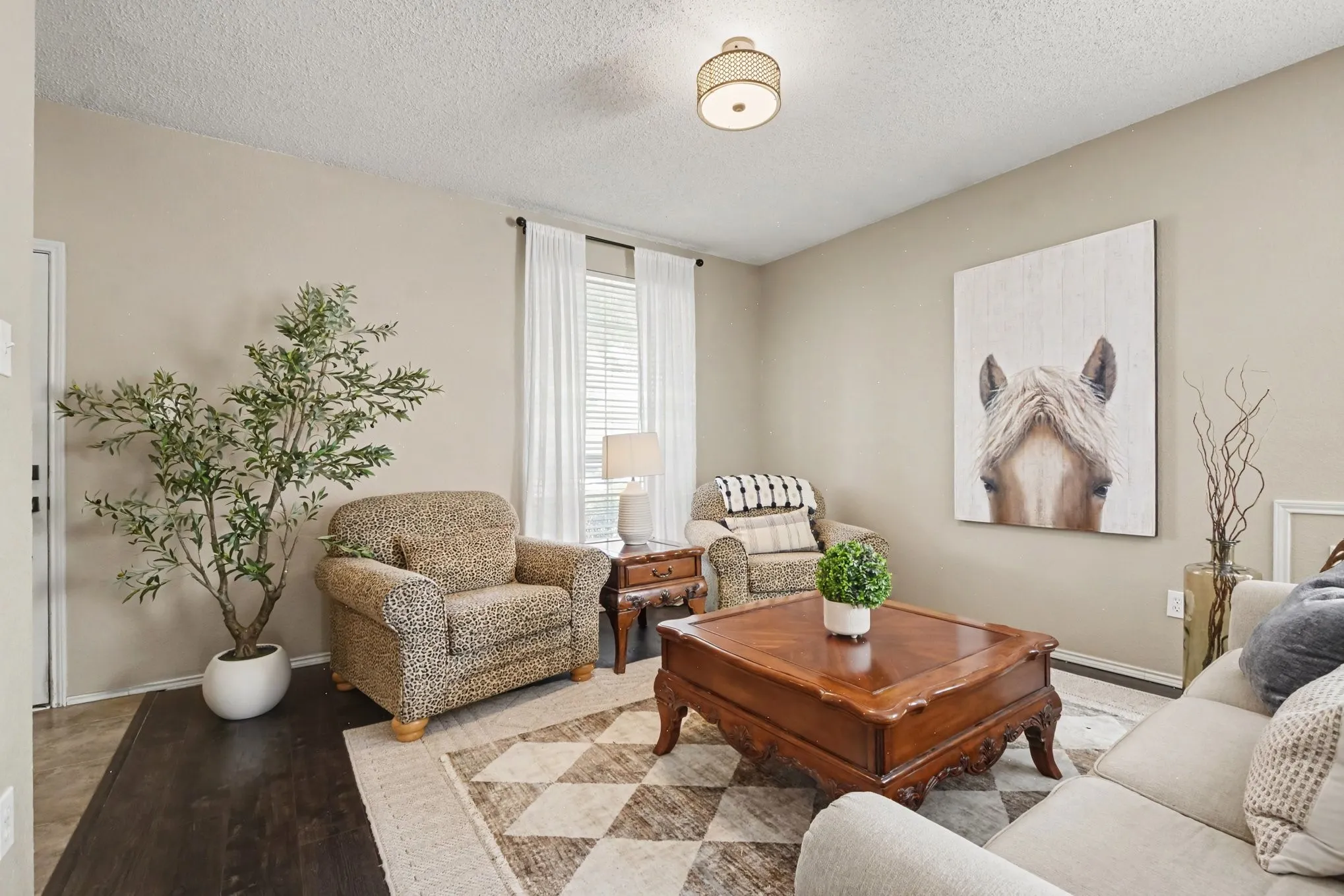 Living area featuring wood-finish flooring, neutral wall tones, and a window with blinds