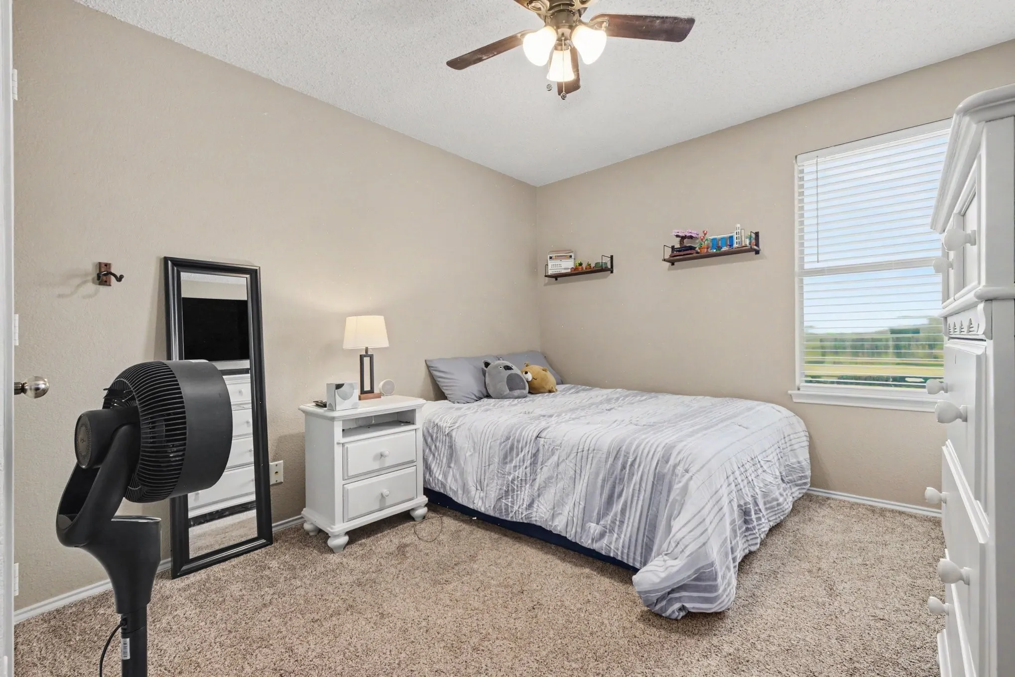 Neutral-toned bedroom featuring carpet flooring and a ceiling fan with integrated lighting
