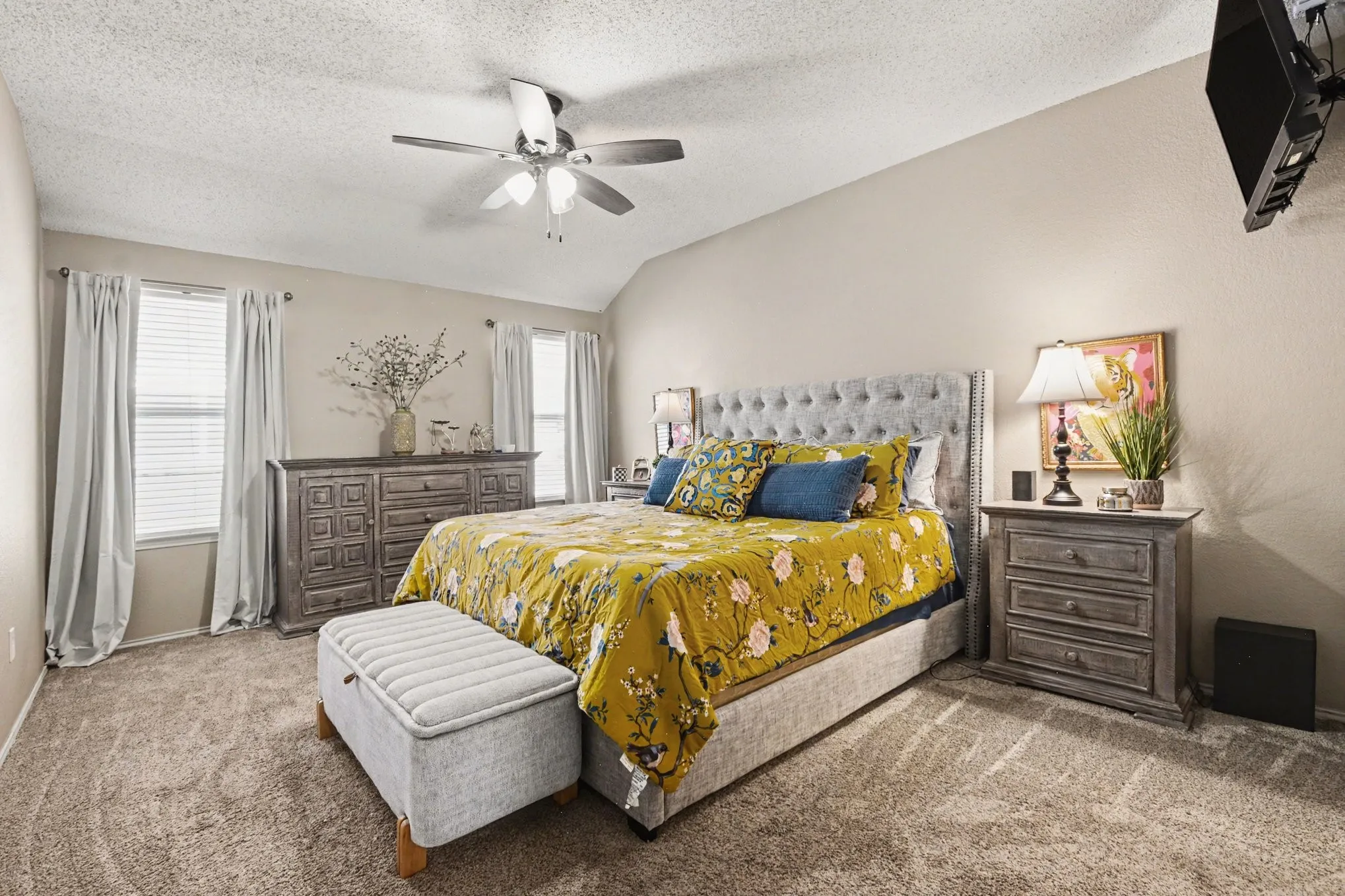 Spacious room featuring vaulted ceilings and neutral wall tones