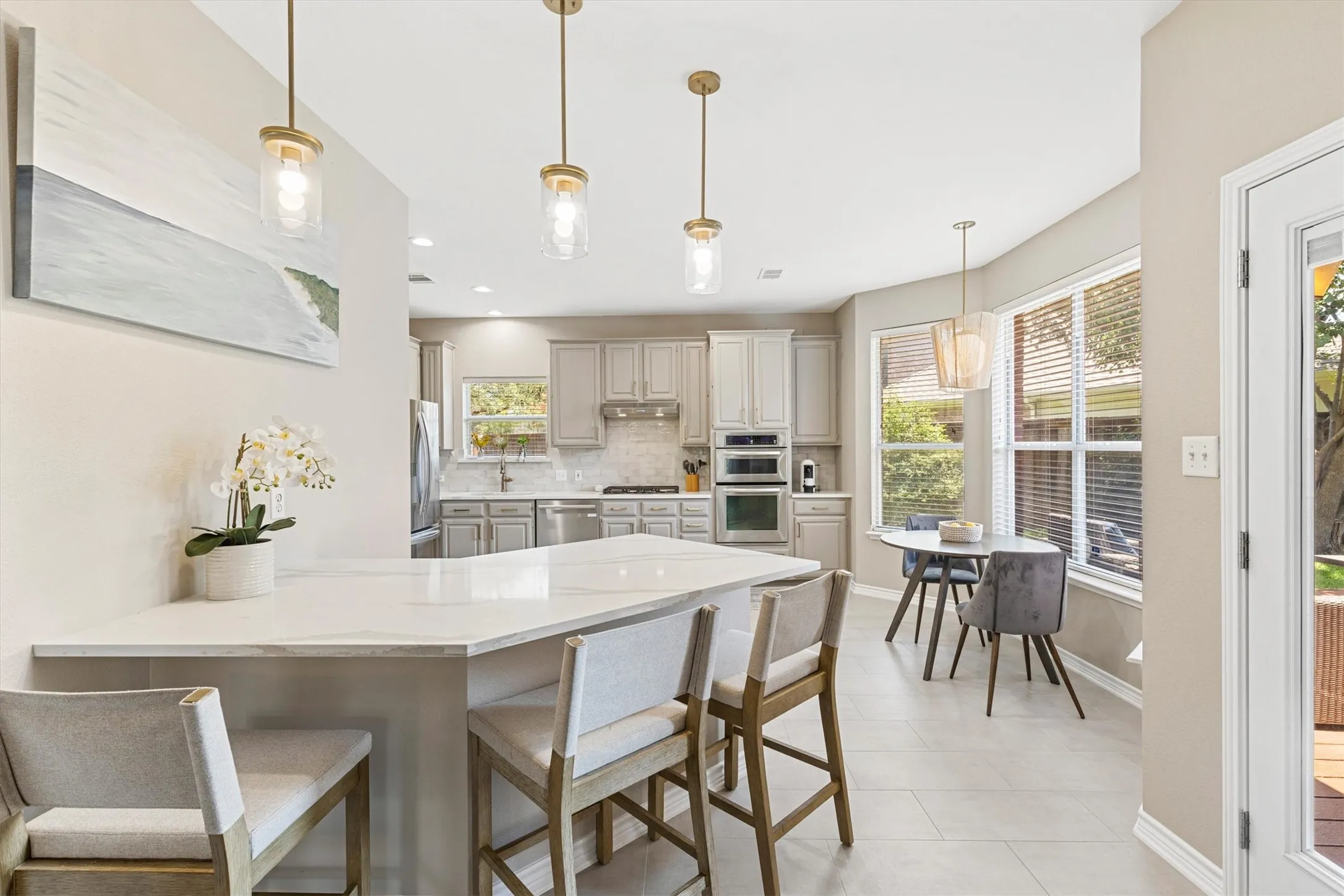 Reimagined Kitchen with Quartz Countertops and Wall of Windows overlooking the Back Yard
