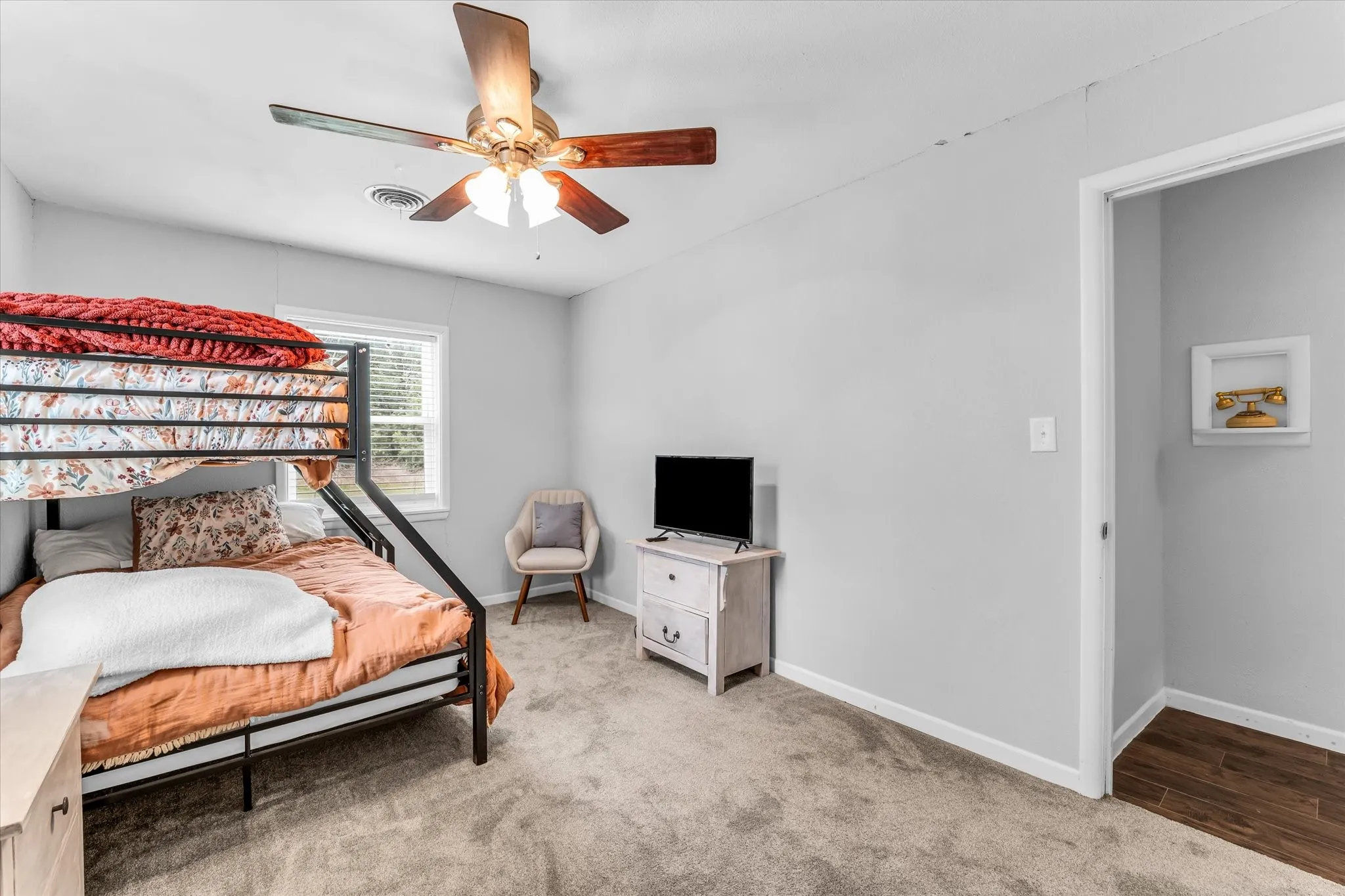 Light gray walls with a ceiling fan featuring wood-finish blades and integrated lighting