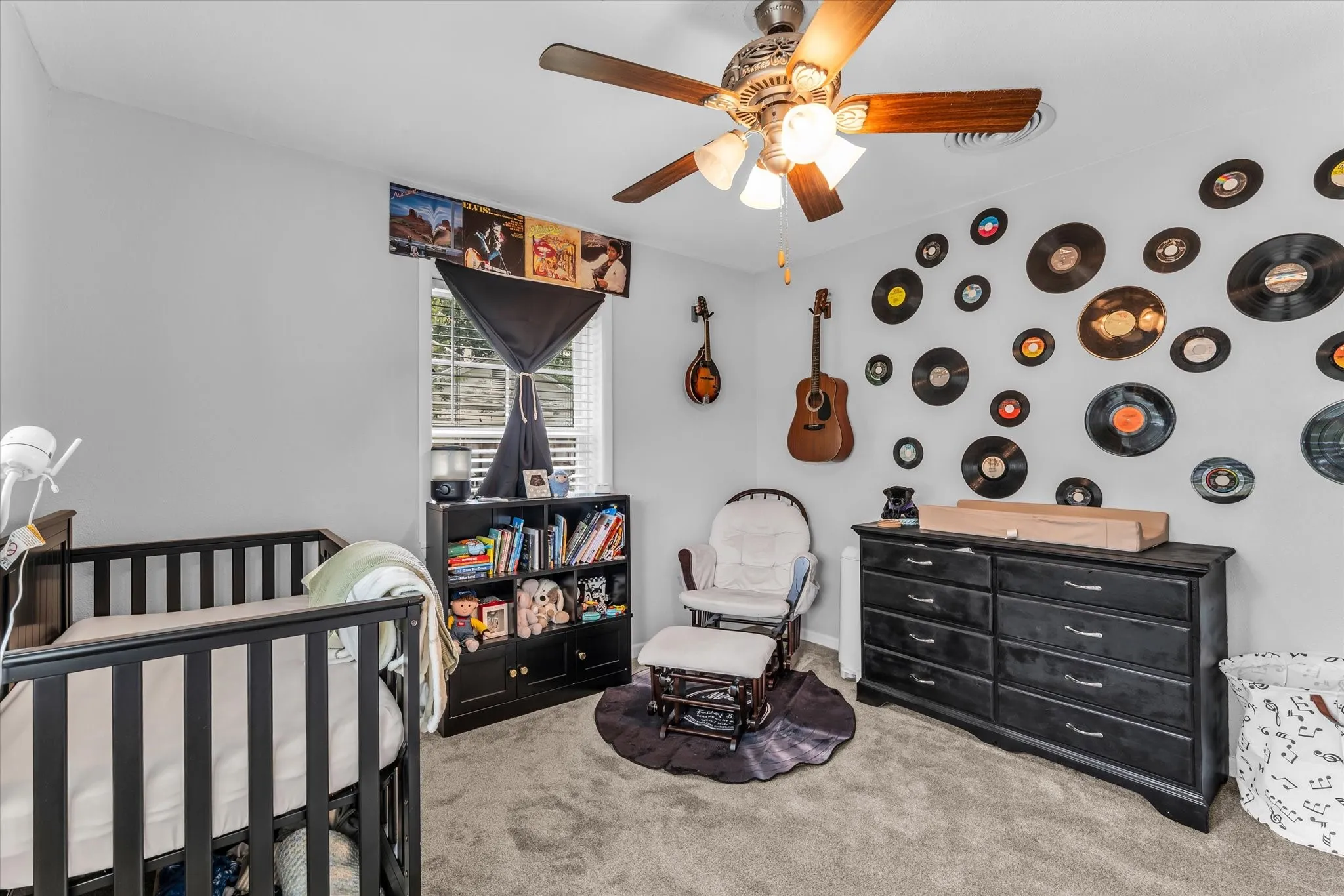 Bedroom featuring light gray walls, plush carpet flooring, a ceiling fan with integrated lighting, and a window with blinds