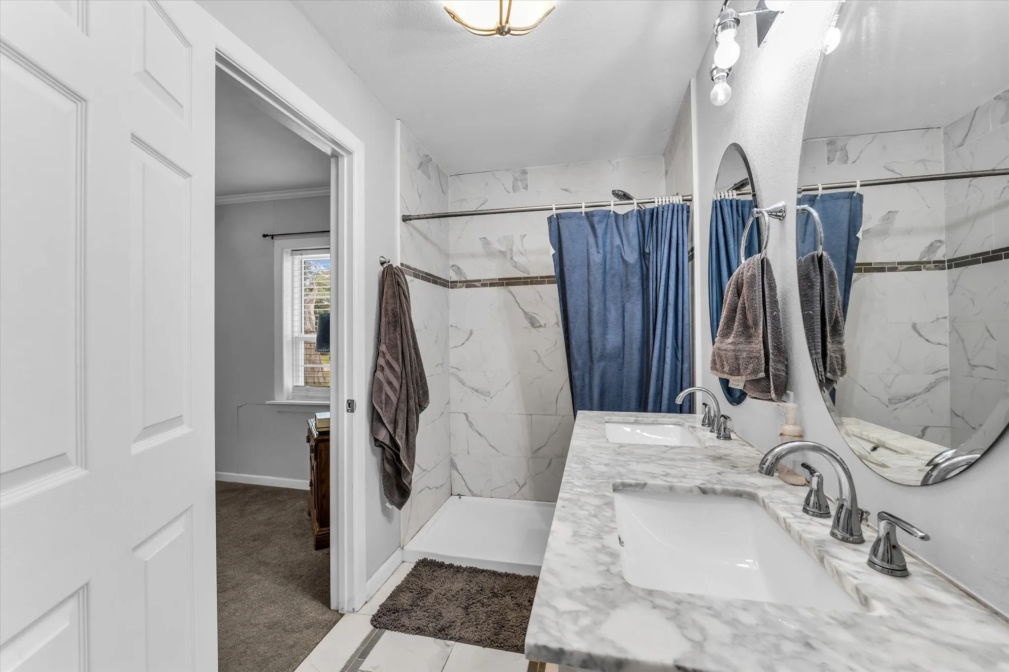 Bathroom featuring a double vanity with integrated sinks and stone countertops