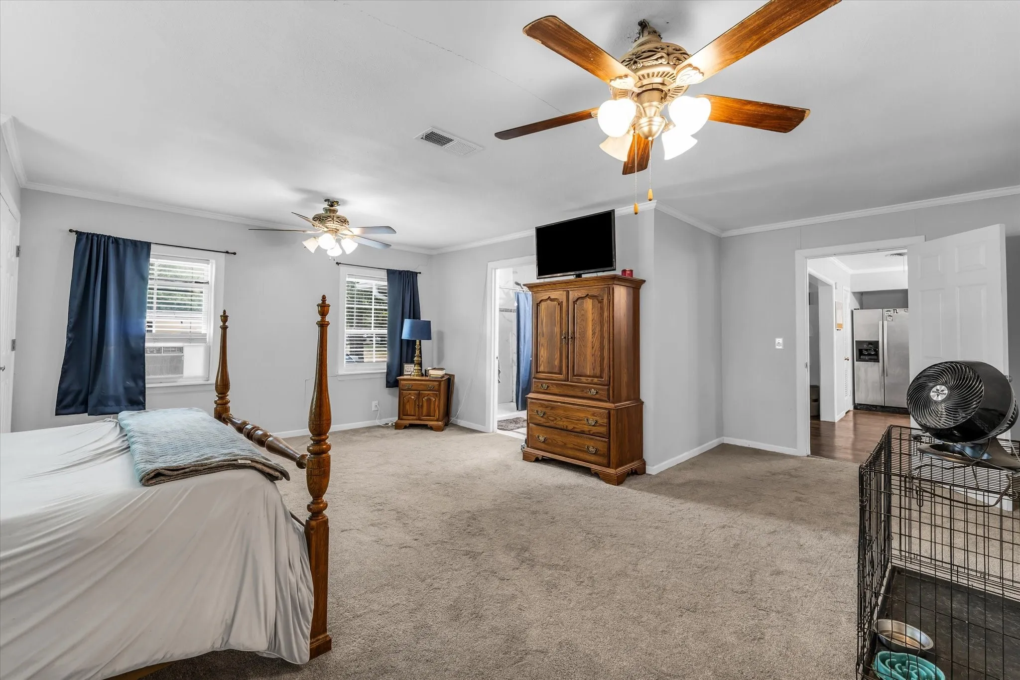 Carpeted bedroom with neutral wall color and crown molding