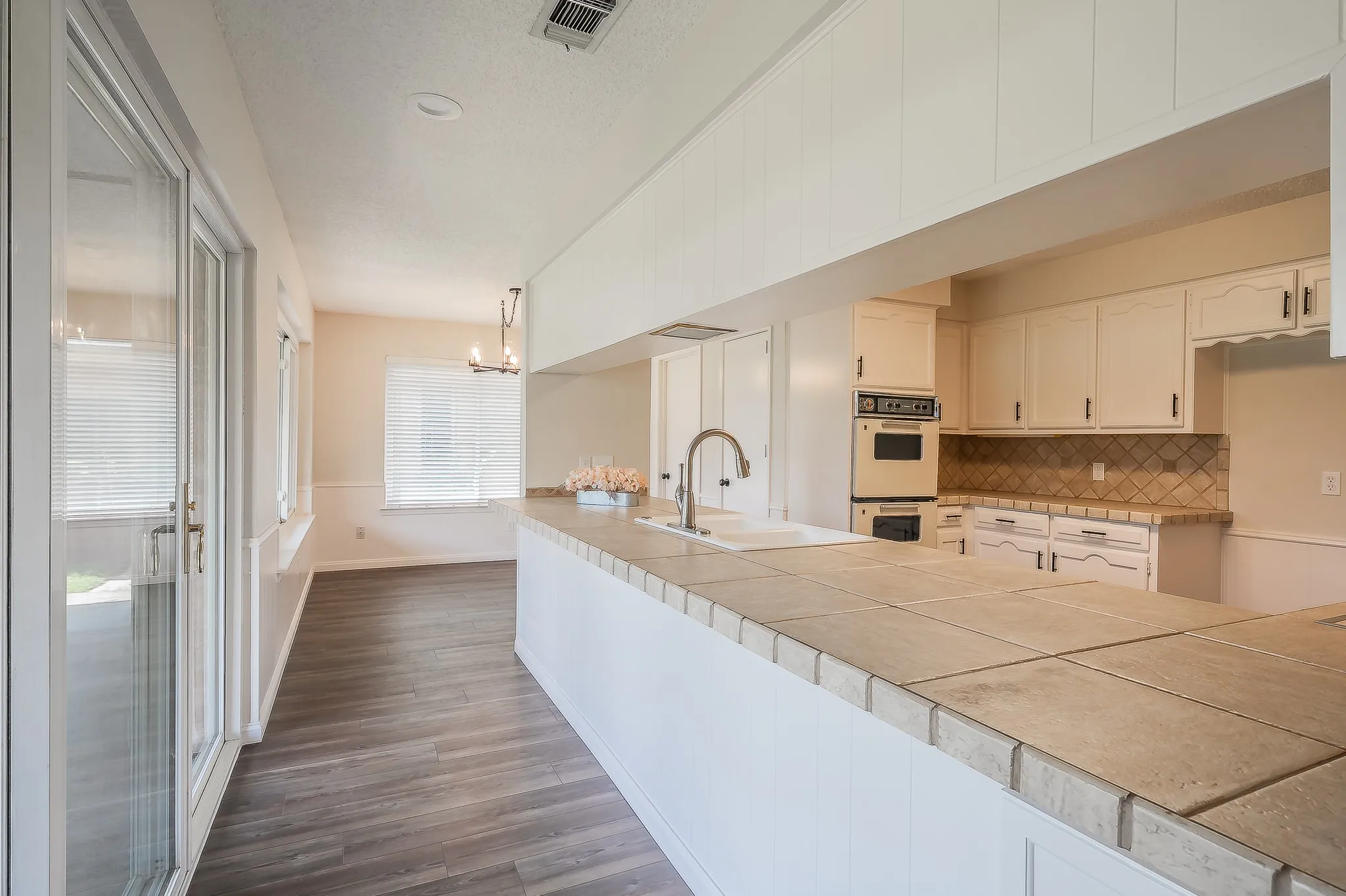 Lovely kitchen featuring a double oven, natural lighting, and a sink overlooking the backyard.