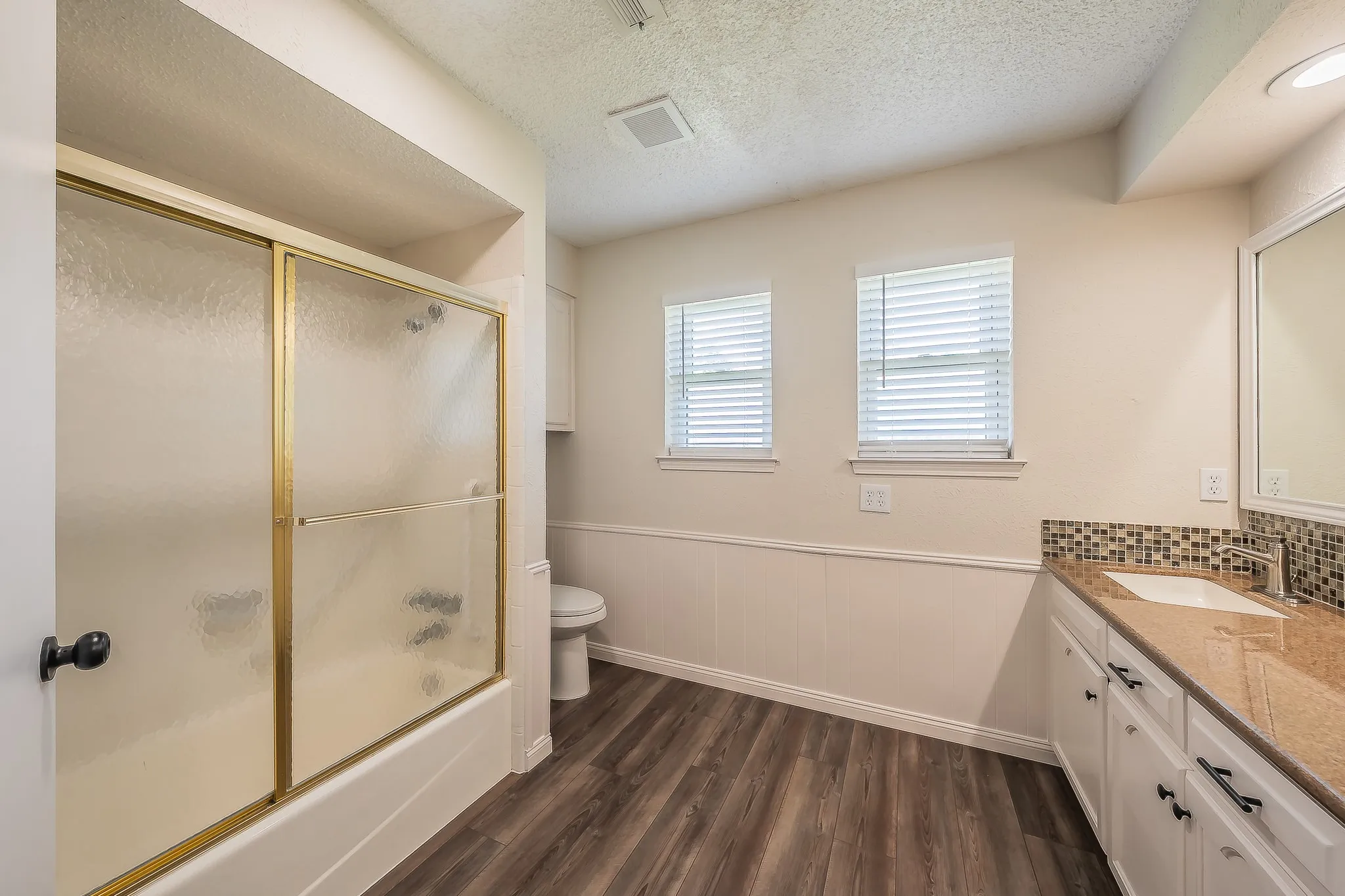 Roomy master bathroom has two windows bring in natural lighting.