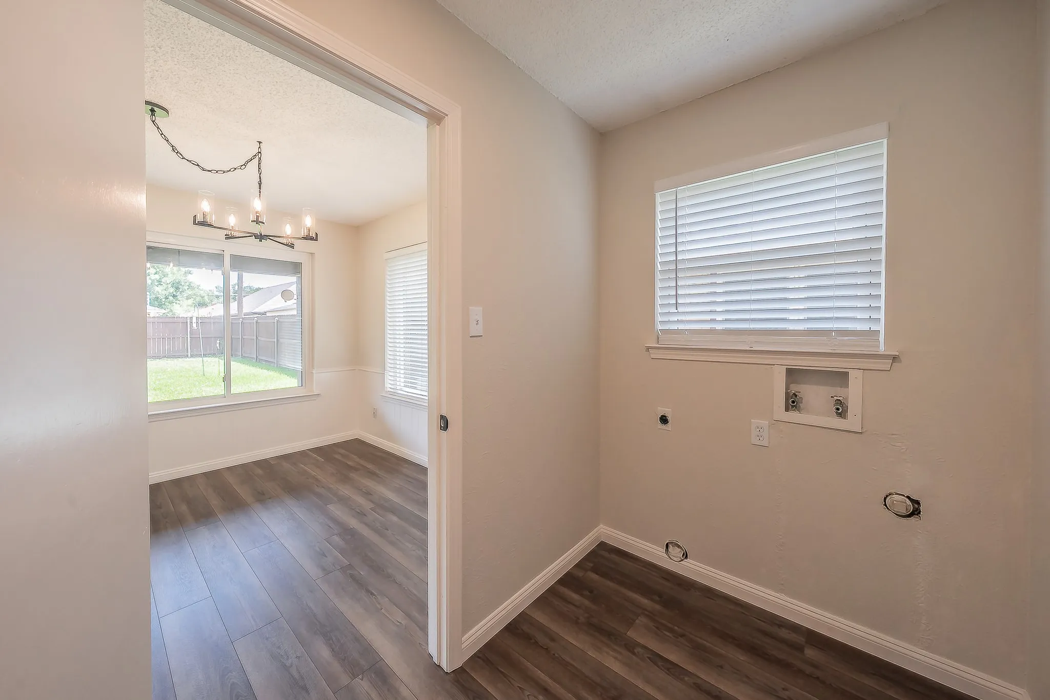 This utility room is equipped with connections for a newer model washer and electric dryer.