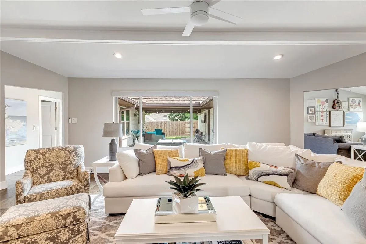 Living area featuring large picture window overlooking tranquil patio.