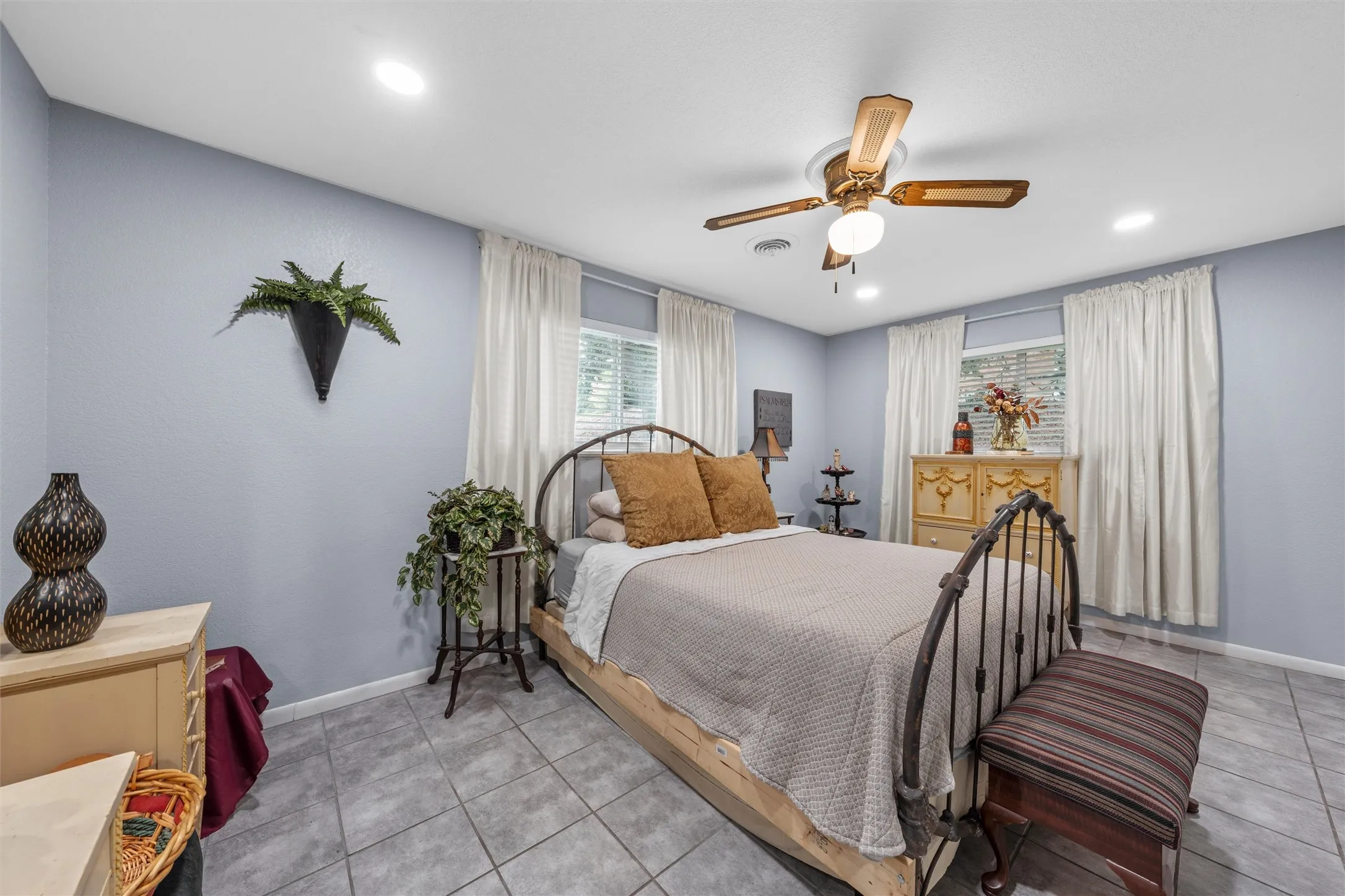 Spacious room featuring tile flooring, light blue wall paint, and white trim