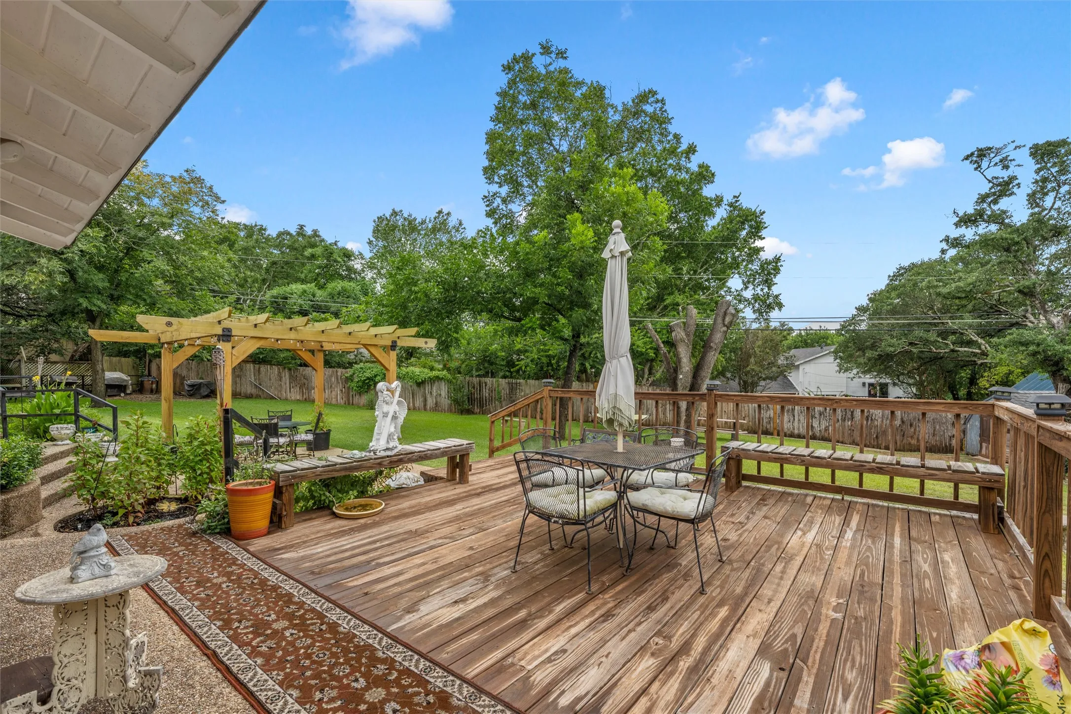 Spacious backyard featuring a multi-level wooden deck with perimeter railing and built-in benches