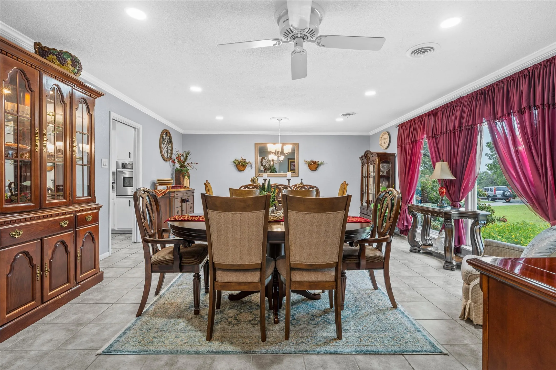 Expansive dining area featuring tile flooring, crown molding, recessed lighting, and a ceiling fan