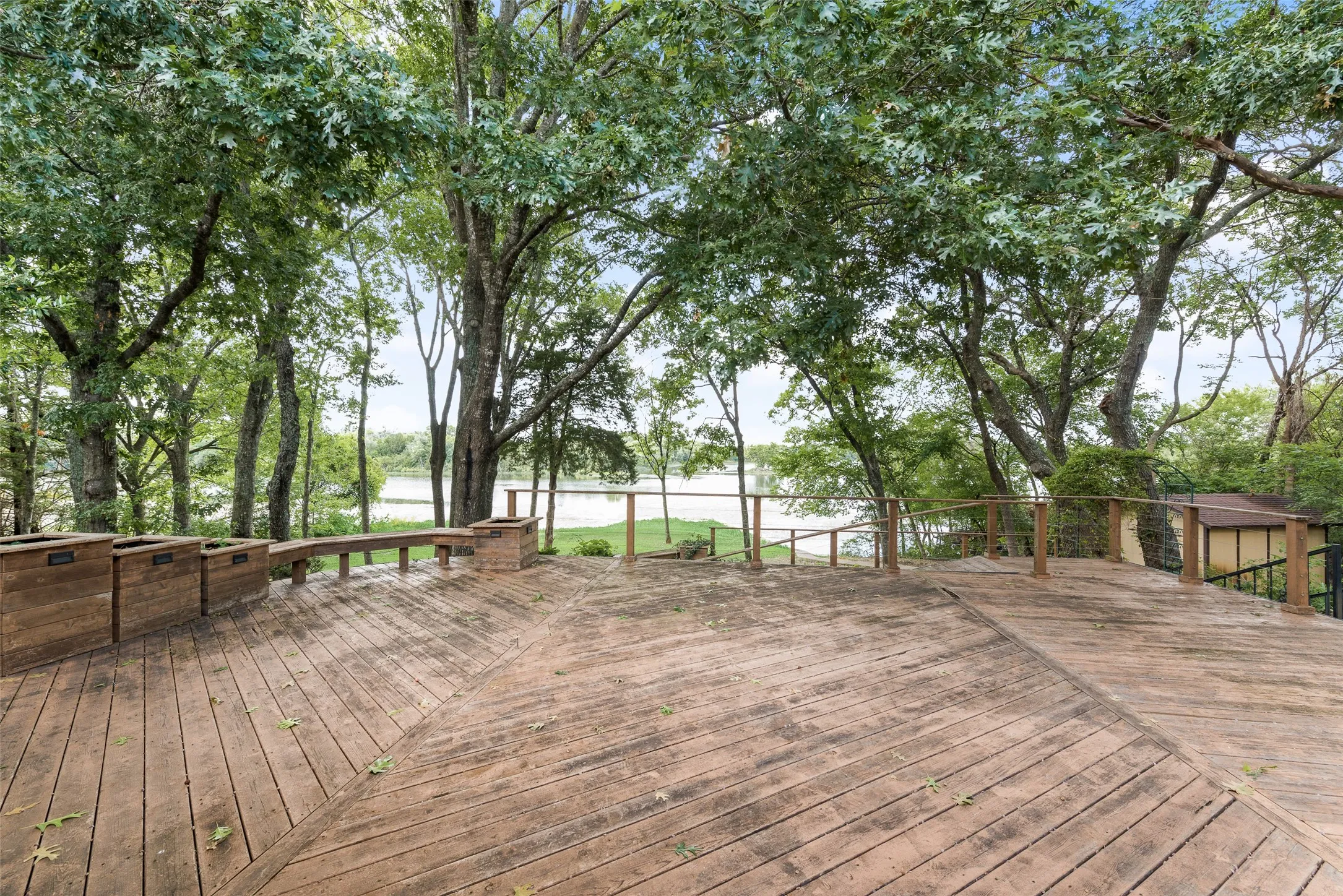 Expansive wood-finish deck with built-in planters and seating