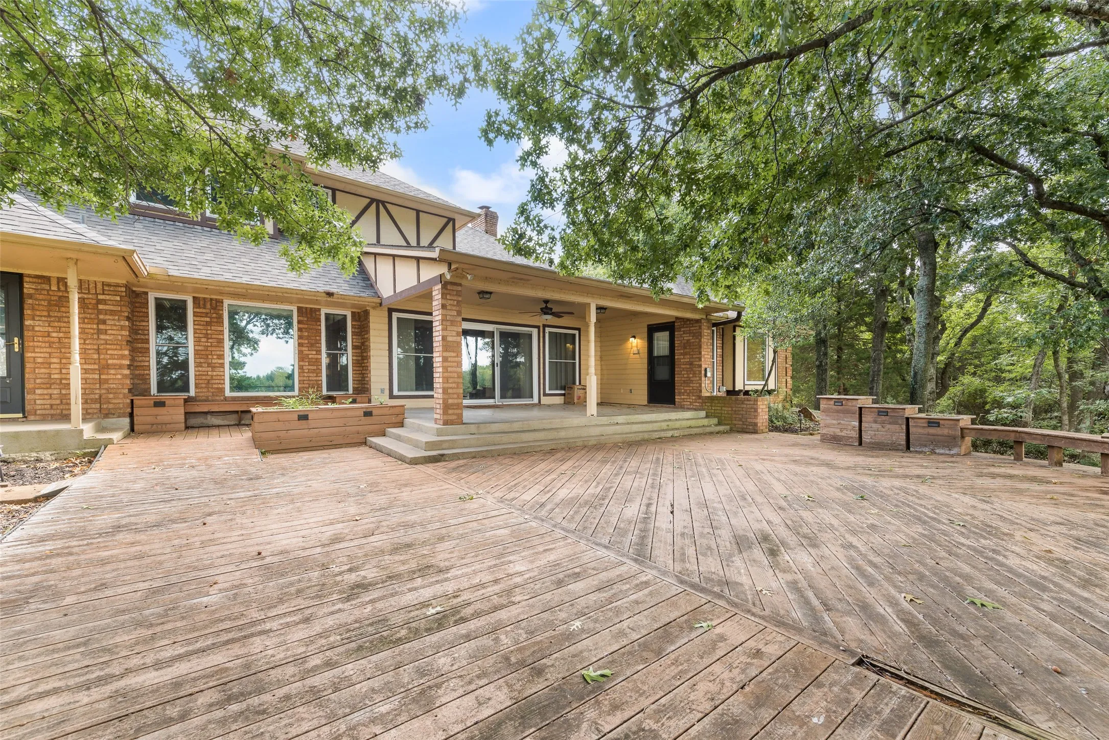 Extensive wood deck with multiple levels, featuring built-in planters and bench seating