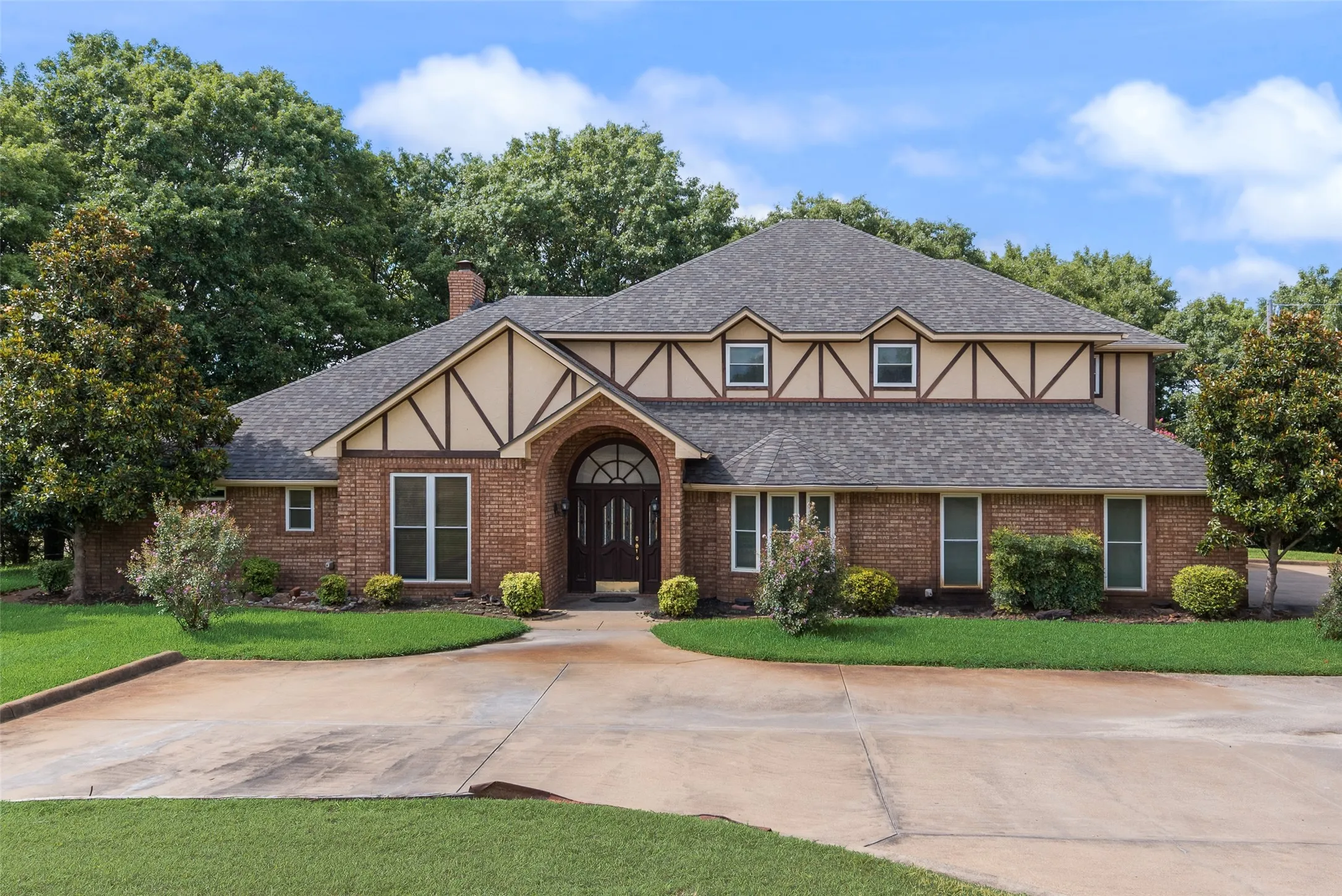 Brick exterior with a prominent arched entry and decorative double front doors