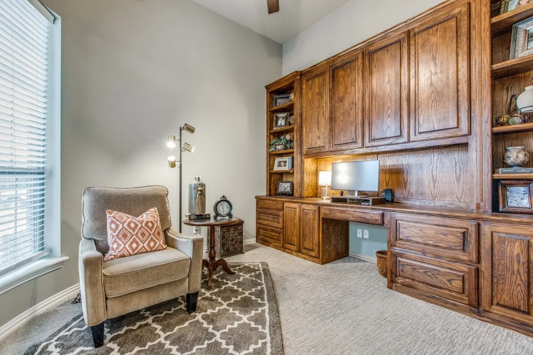 Built-in wood cabinetry with a desk area, integrated shelving, and upper storage
