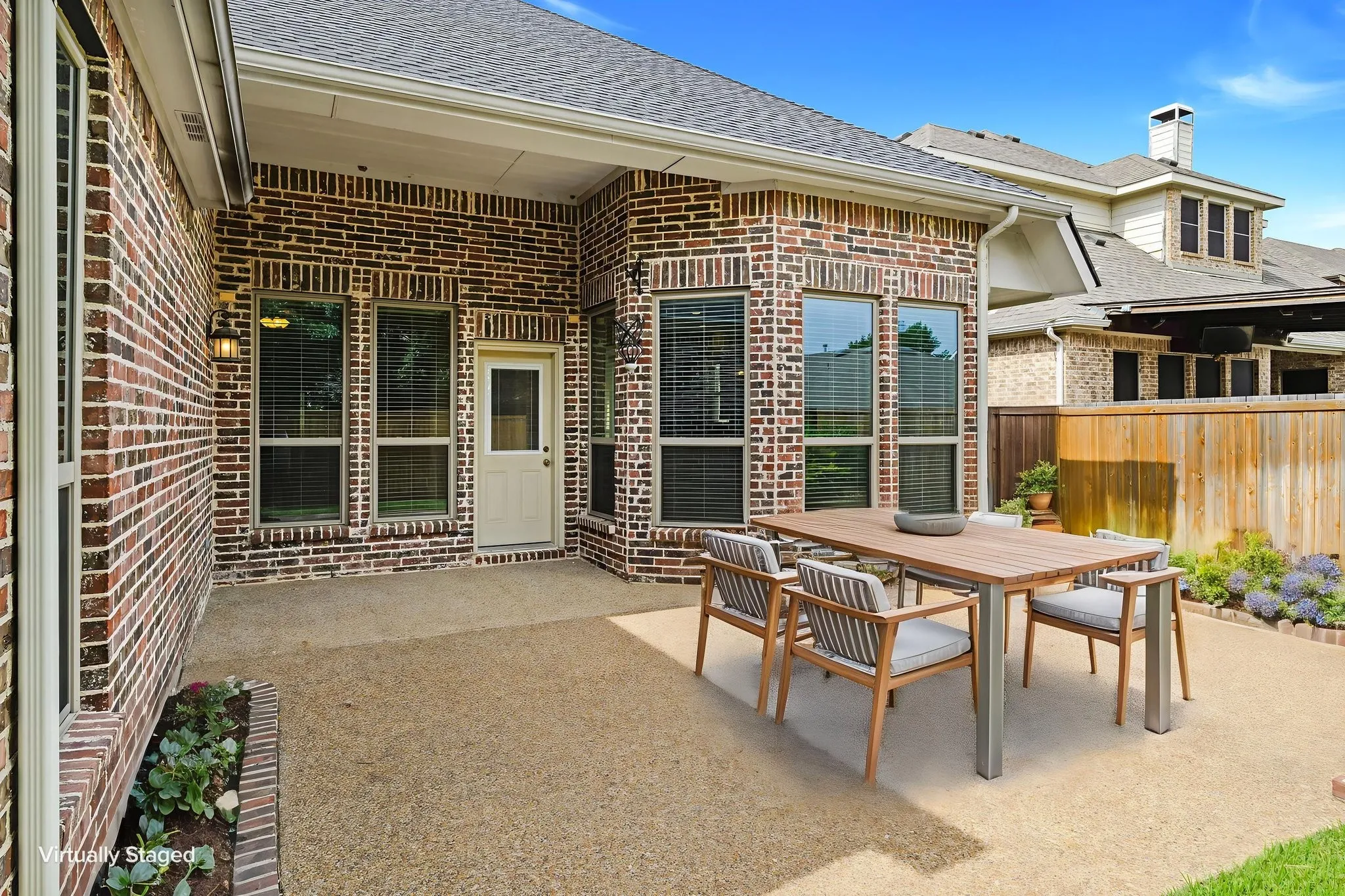 Exterior patio featuring brick architecture and a concrete surface