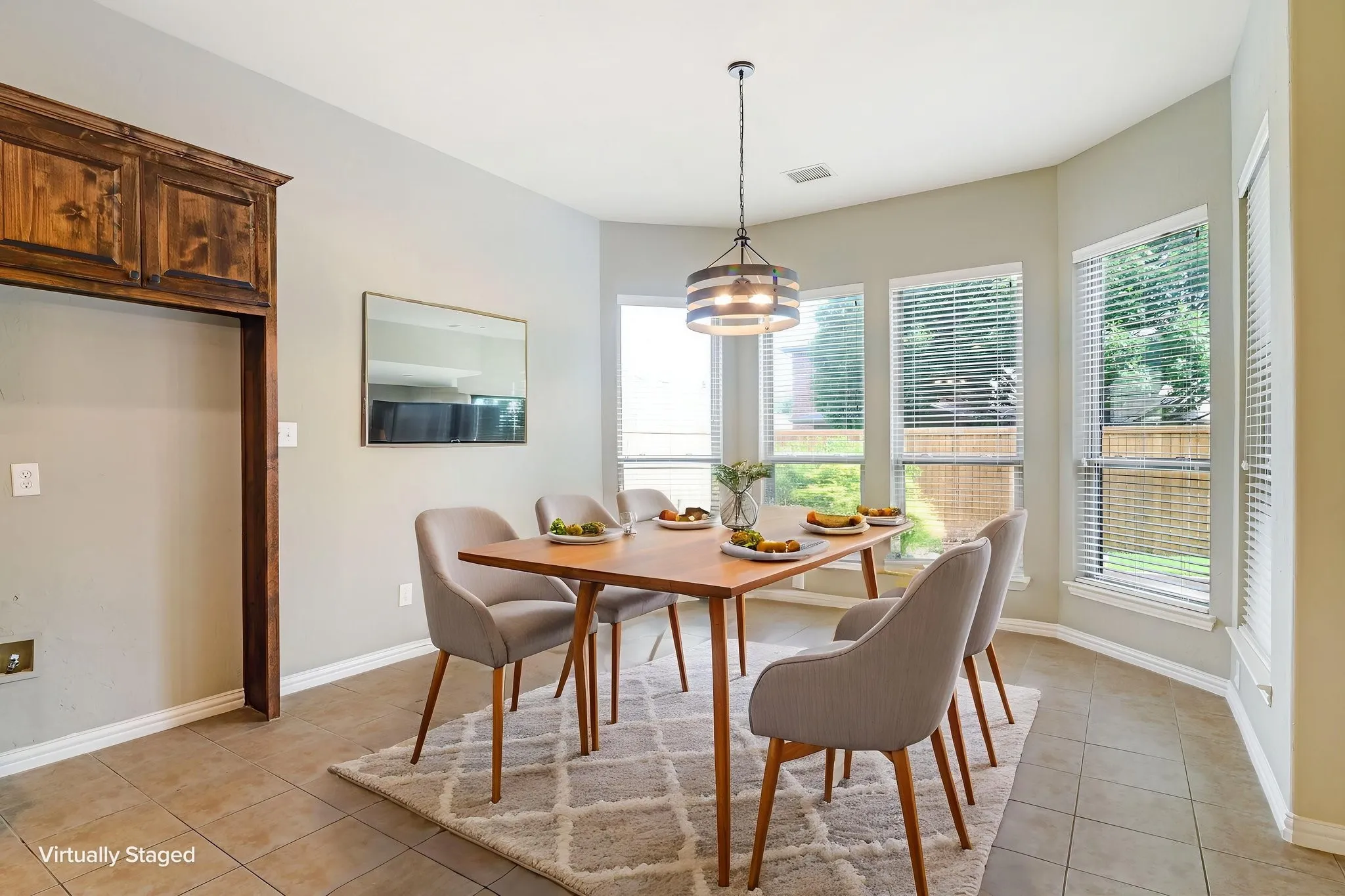 Bay window dining area with tile flooring and a multi-level wood-finish built-in cabinet